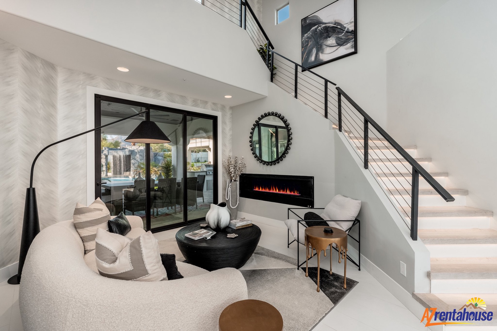 Unwind in your sophisticated living space featuring a cozy fireplace, elegant decor, and modern stairs leading to your upper level retreat.
