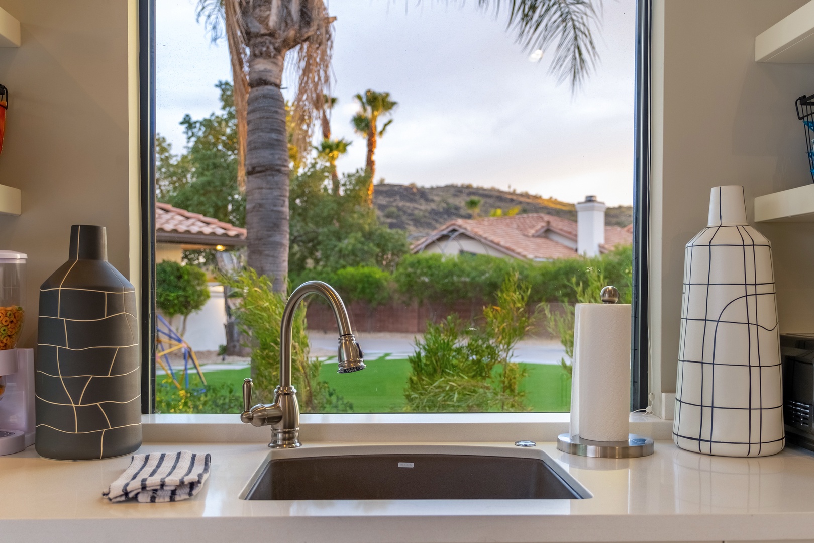 A fully equipped kitchen with a garden view, featuring modern fixtures and stylish décor—perfect for preparing your favorite meals while enjoying the lush scenery outside.