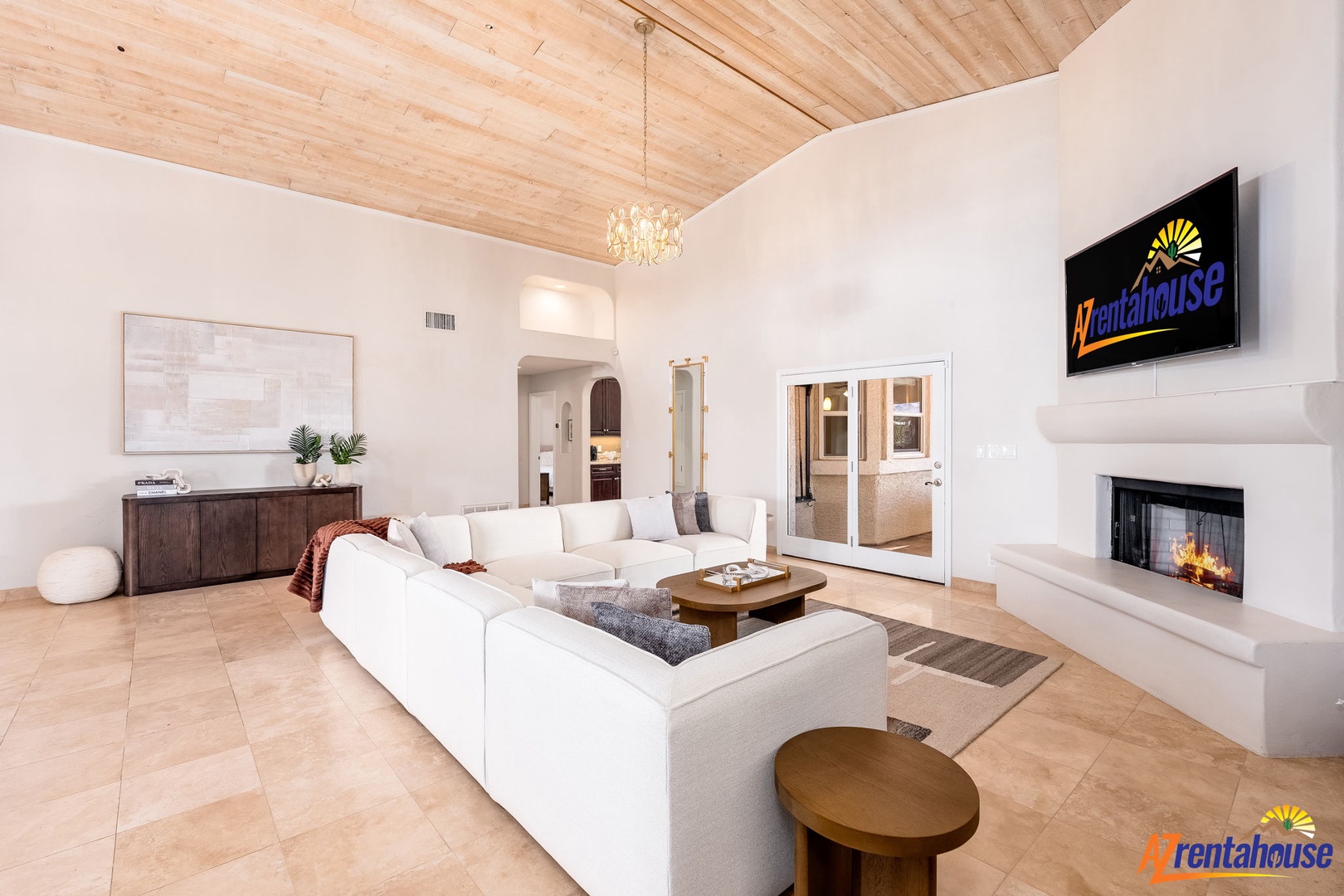 Sink into plush seating beneath soaring wood ceilings and warm yourself by the fireplace in this inviting living space designed for your ultimate comfort.