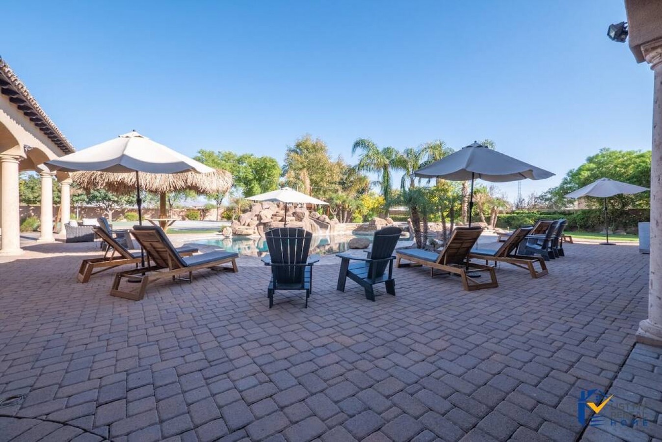 Step onto your private patio where comfortable loungers and shaded seating await around the sparkling pool—perfect for sunny afternoon relaxation.