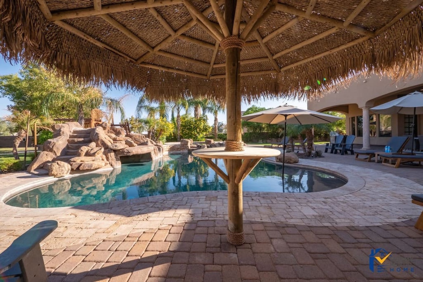 Relax under tropical thatched shade beside your private pool oasis, complete with waterfall feature and spacious patio for ultimate outdoor enjoyment.