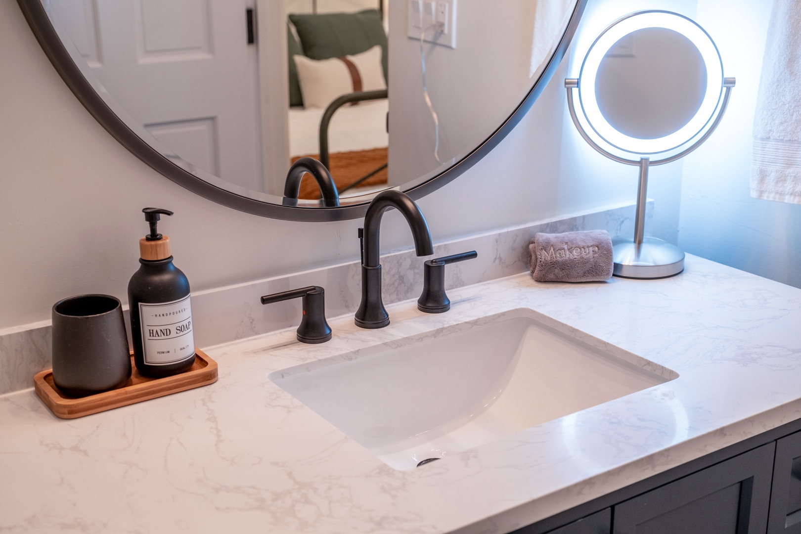 Freshen up at your modern vanity with sleek fixtures, bright lighting, and thoughtful touches like hand soap and a makeup mirror to start your day right.