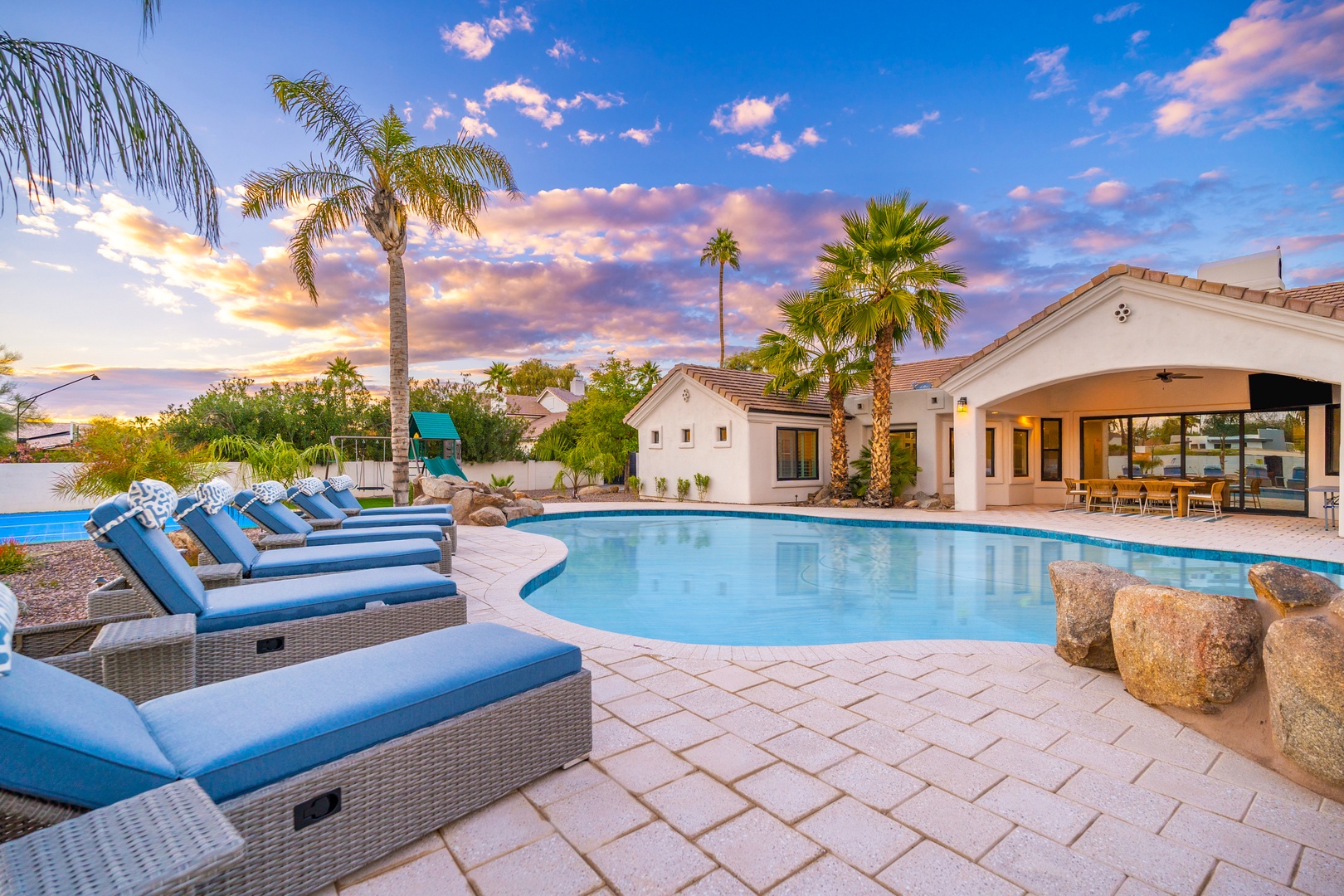 Unwind on plush poolside loungers beneath swaying palms as the desert sky paints itself in shades of pink and gold—your private oasis awaits.