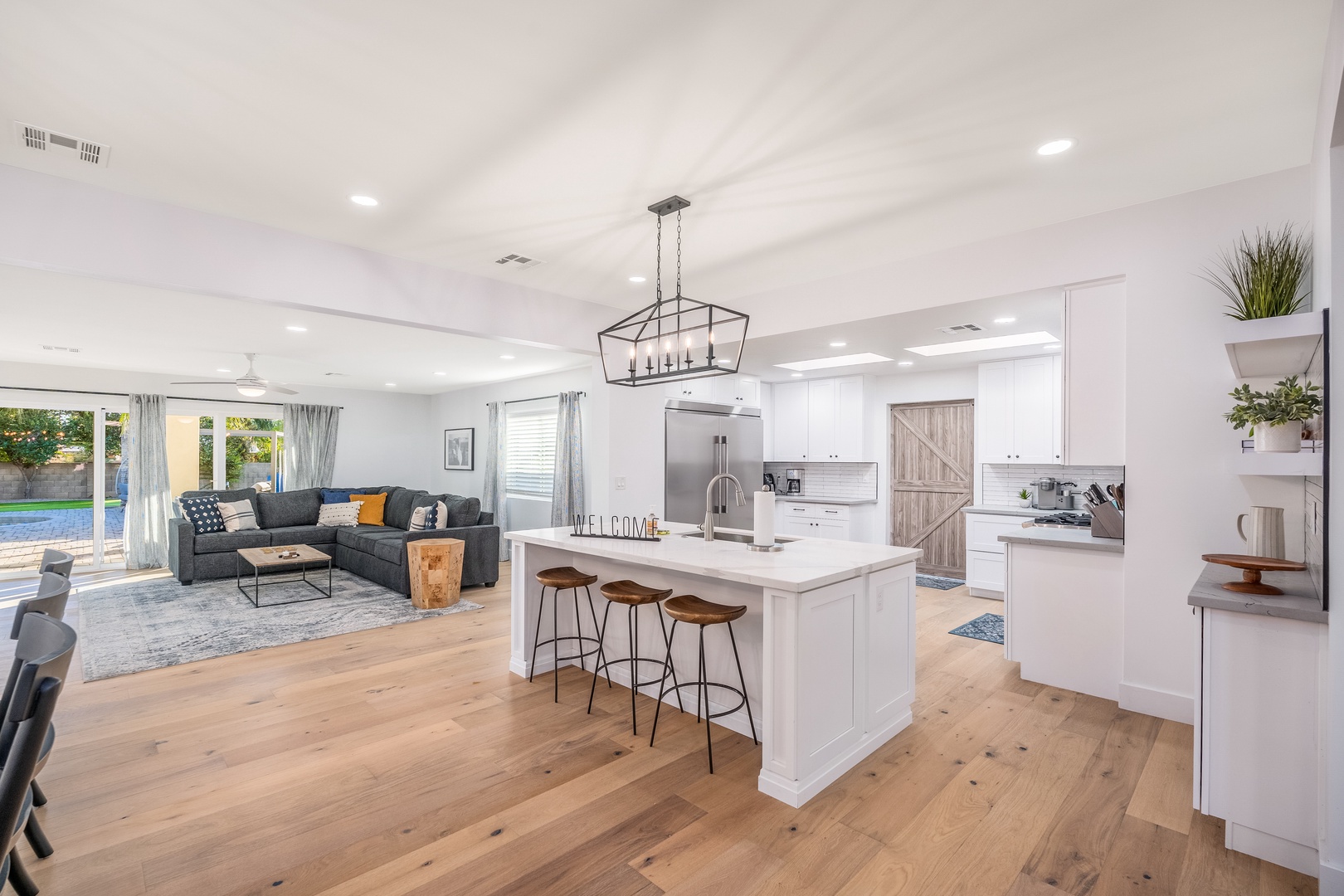 Step into your bright, open-concept living space where modern comfort meets effortless style. Gather around the sleek kitchen island, relax on the plush sectional, and enjoy seamless indoor-outdoor flow through stunning glass doors.