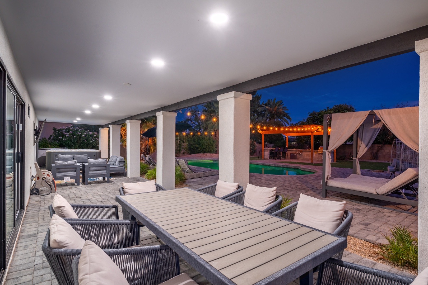 Unwind on your covered terrace with plush seating overlooking the pool, cabana, and lush tropical landscaping—perfect for evening relaxation under the stars.