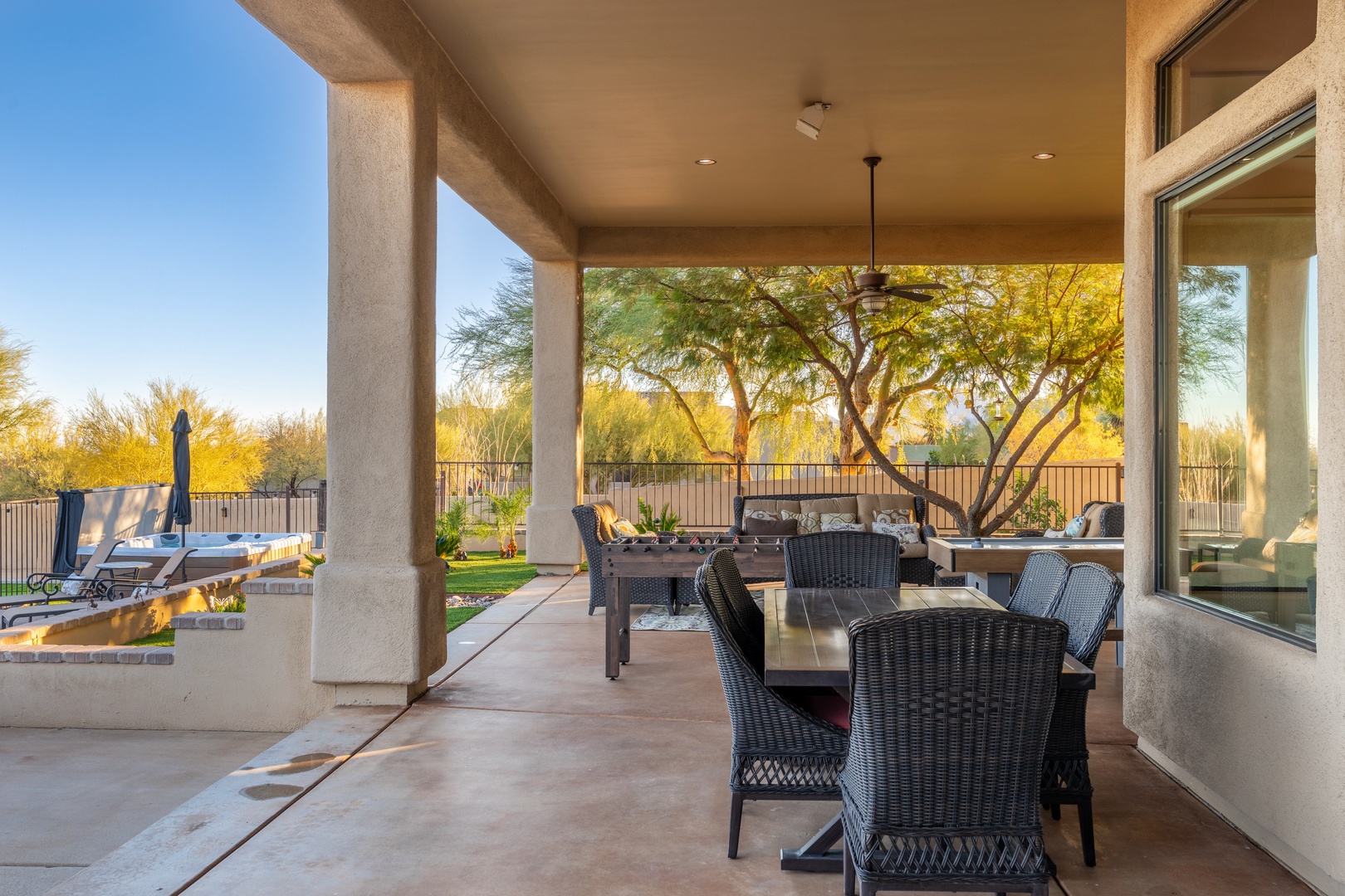 Your private covered patio invites al fresco dining with desert views framed by mature trees, plus loungers by the pool for ultimate relaxation.