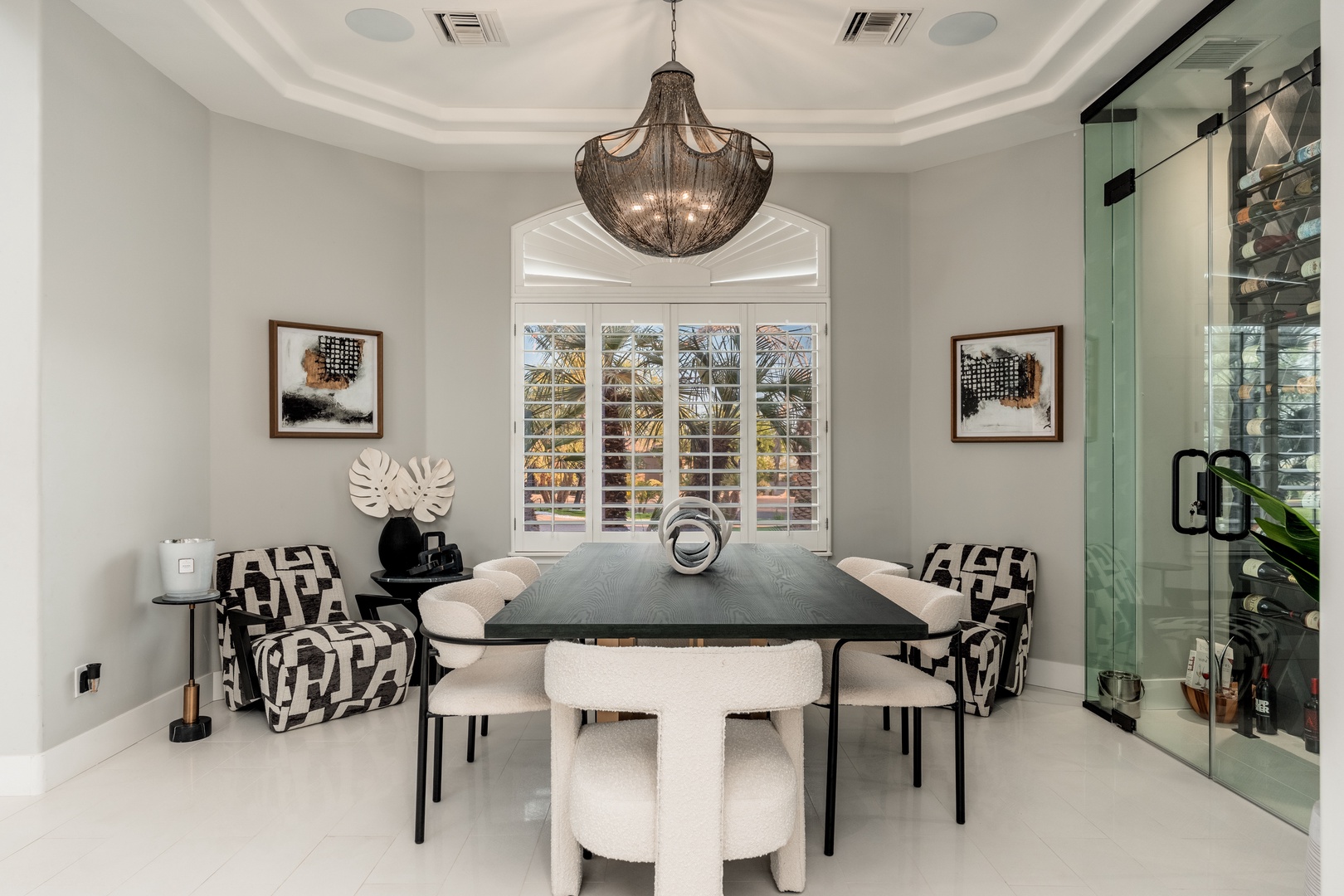 Gather around the elegant dining table under a stunning chandelier, where memorable meals and conversations await. The sophisticated decor creates an inviting atmosphere for your special occasions.