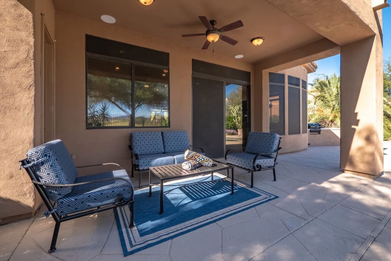 Relax in your private covered patio with comfortable seating, perfect for morning coffee or evening conversations under the desert sky.