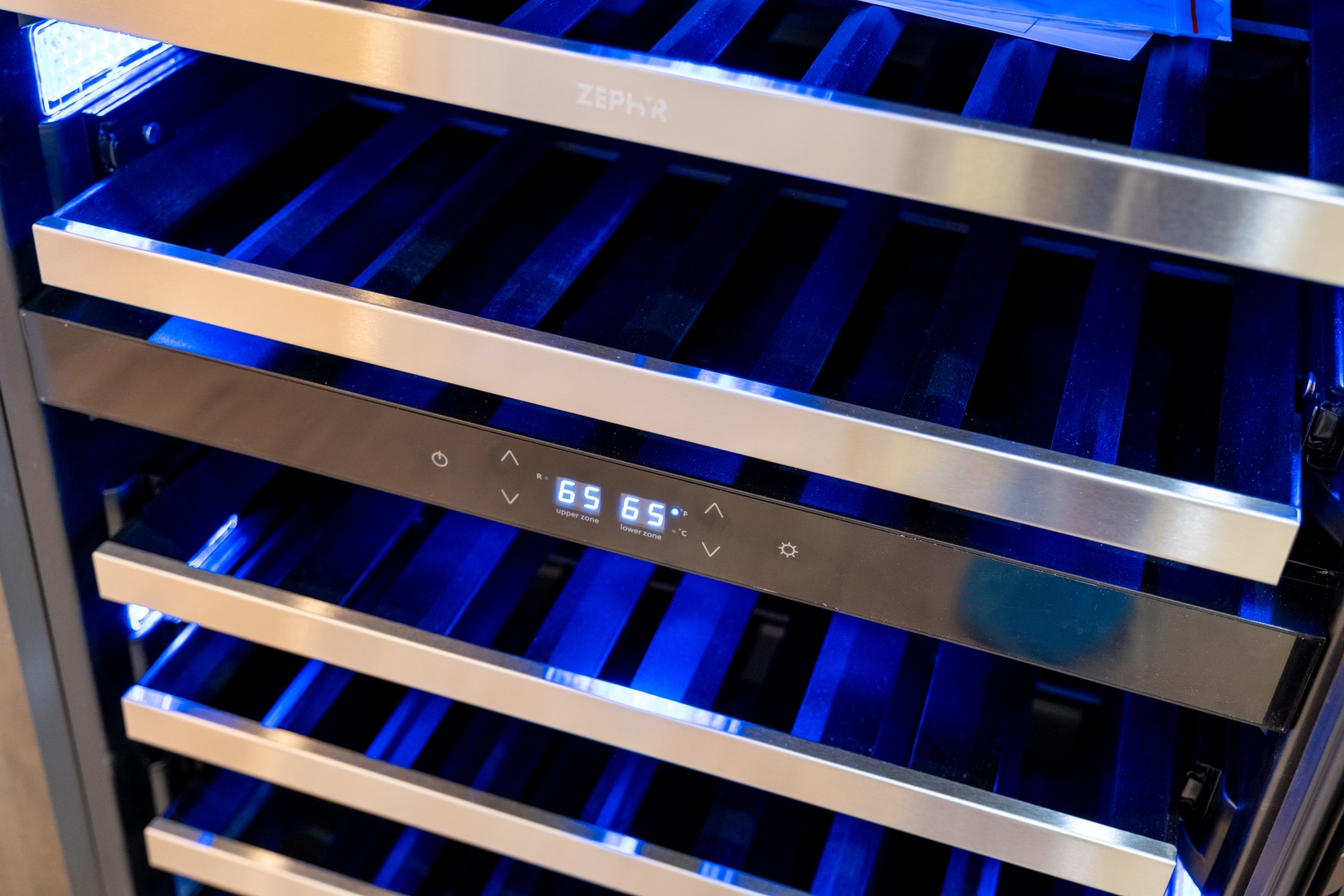 A dual-zone wine cooler with sleek stainless steel shelves and ambient blue LED lighting, perfect for keeping your favorite bottles at ideal temperature.