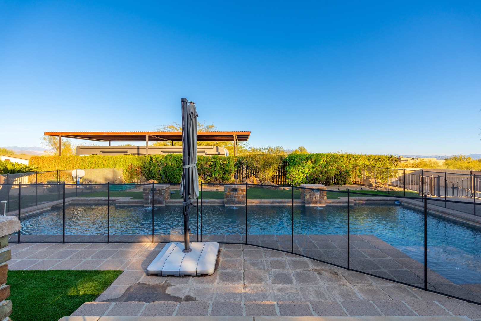 Modern desert estate pool and patio set within expansive vineyard and mountain views under bright Arizona skies.