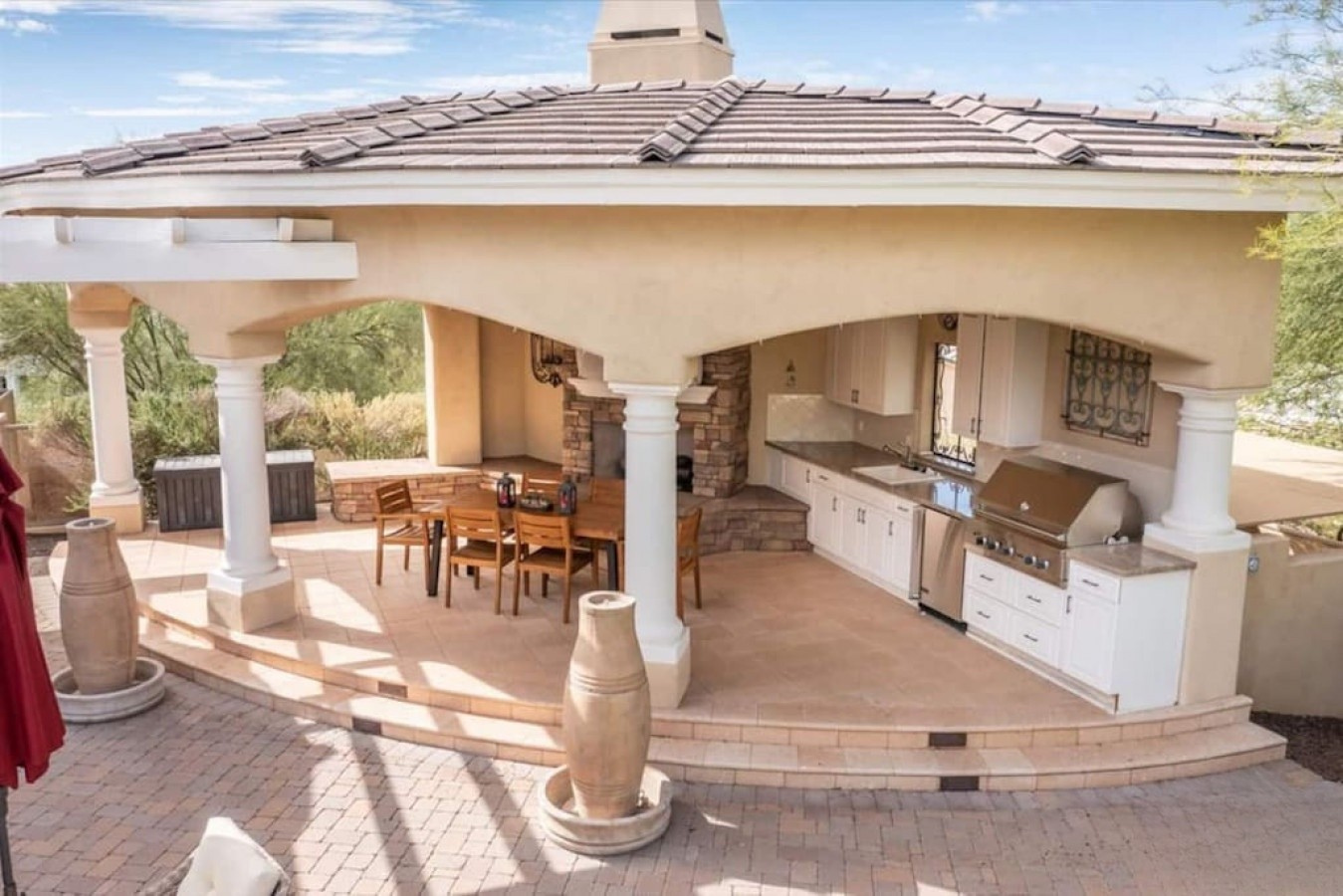 Your private outdoor kitchen and dining pavilion awaits, where you can grill, dine, and entertain under the shade of elegant columns and a tiled roof.