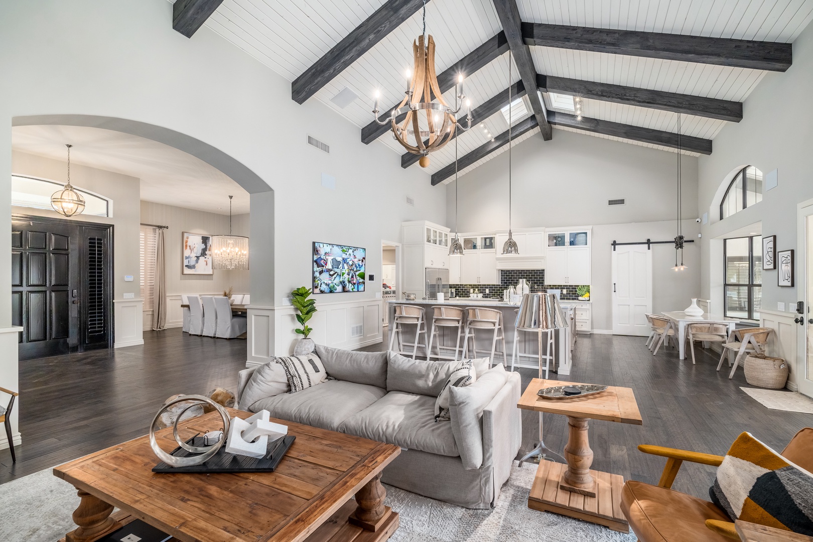 Your stunning open-concept retreat features soaring vaulted ceilings with rustic beams, plush seating, and a bright modern kitchen—perfect for unwinding or gathering together in style.