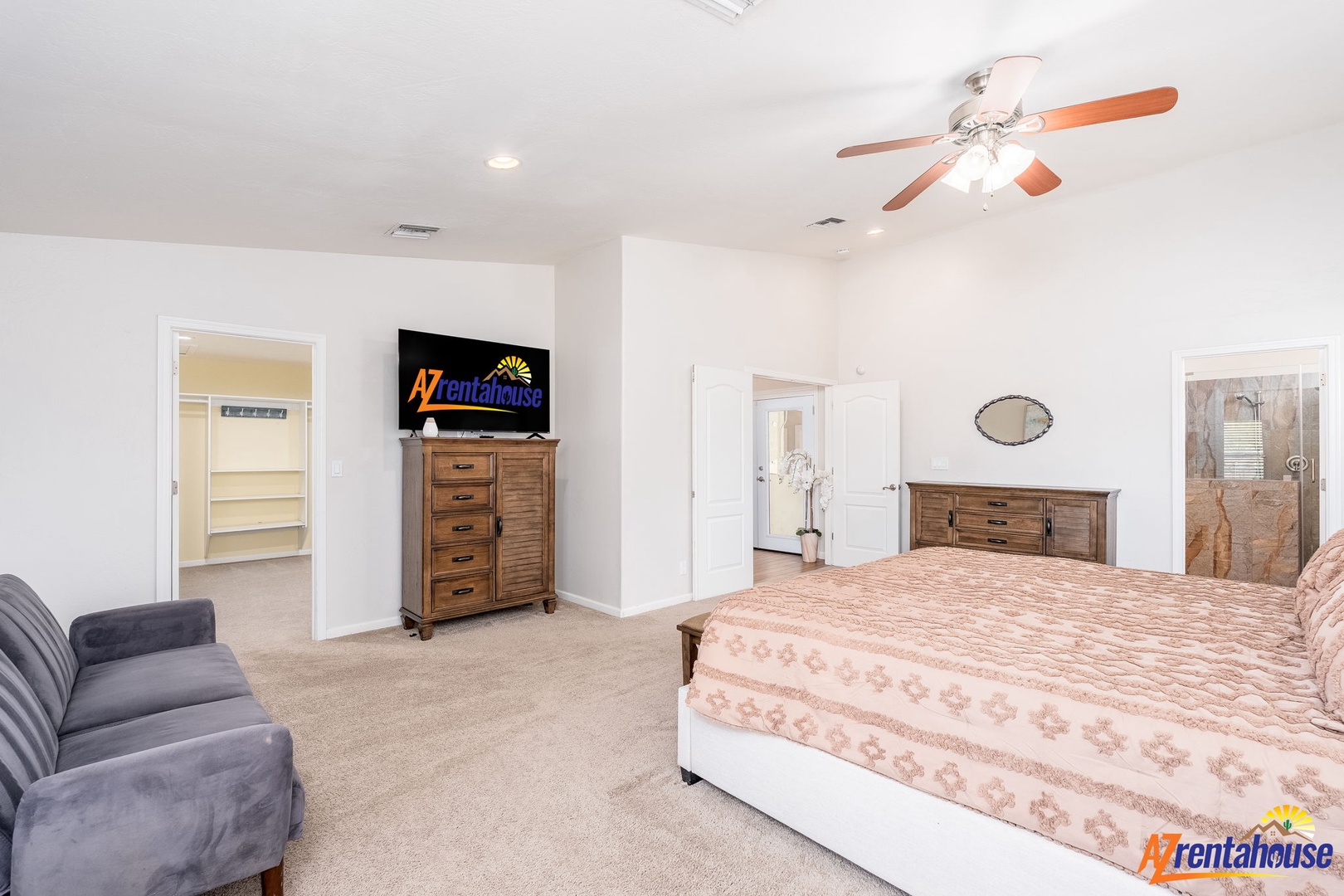 A spacious primary suite offering comfort and style, with a cozy bed, relaxing seating, and a large walk-in closet ready for all your belongings.