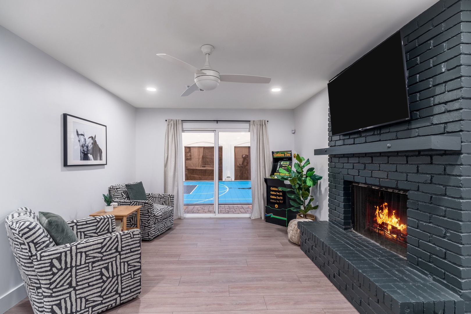 Unwind in your stylish living space, where a cozy fireplace and modern comforts meet the inviting glow of your private pool just outside the sliding doors.