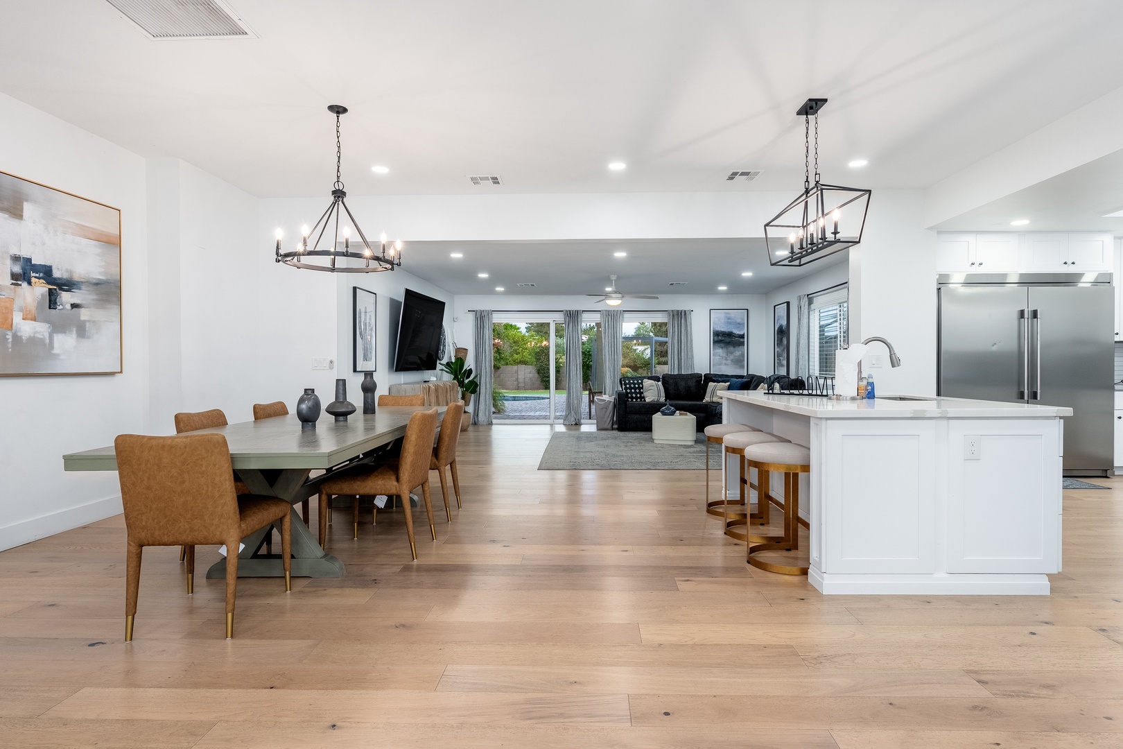 Relax in this spacious, sunlit great room where dining, lounging, and cooking flow seamlessly together—your perfect gathering space with warm wood floors and modern touches.
