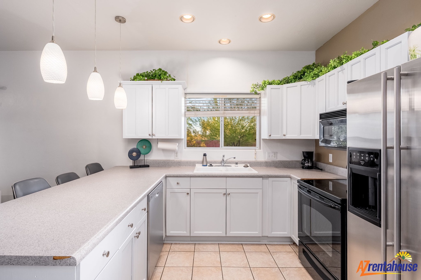 Your spacious kitchen is ready for home-cooked meals, featuring stainless steel appliances, abundant counter space, and a bright window overlooking the greenery outside.