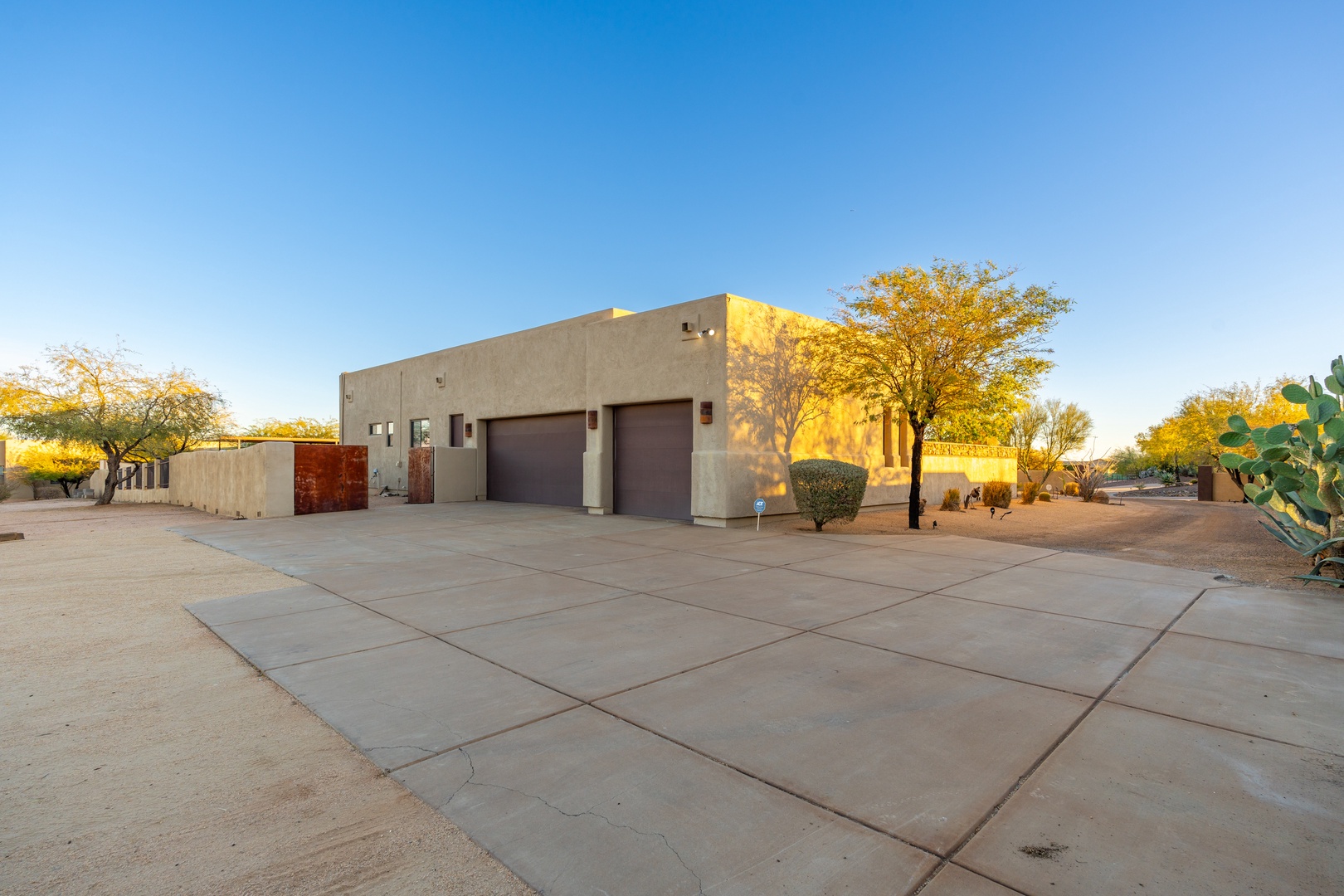 Contemporary desert architecture with spacious driveway and native landscaping, featuring warm desert colors and natural vegetation under open Arizona skies.