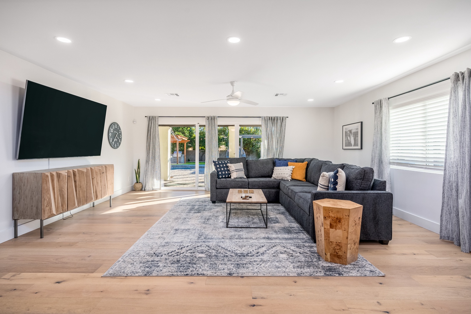 Unwind in this bright, open living room where natural light pours through large glass doors leading to the pool. Sink into the plush sectional and enjoy your favorite shows on the big screen.