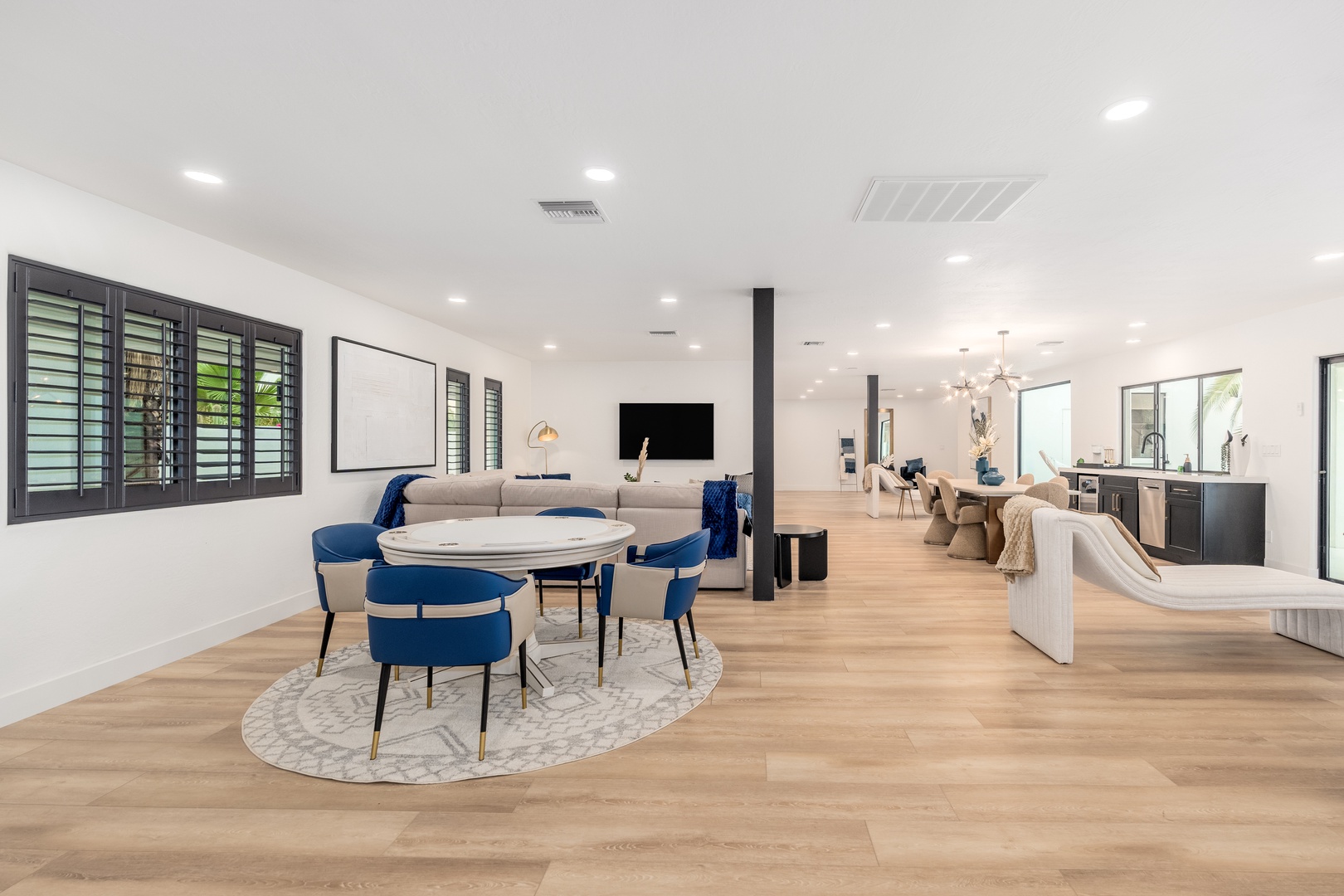 Sunlight fills your elegant, open-concept living space featuring chic seating, a sleek dining area, and a modern kitchen—perfect for gathering and making memories together.