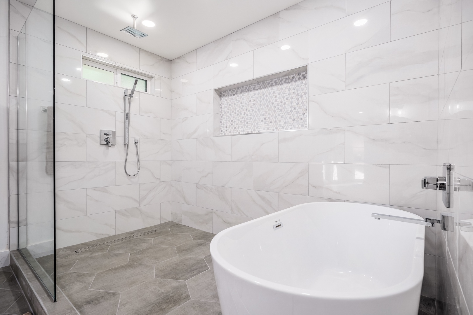 Step into your private spa-like retreat with a luxurious soaking tub and sleek rainfall shower, where modern marble-inspired walls meet tranquil relaxation.