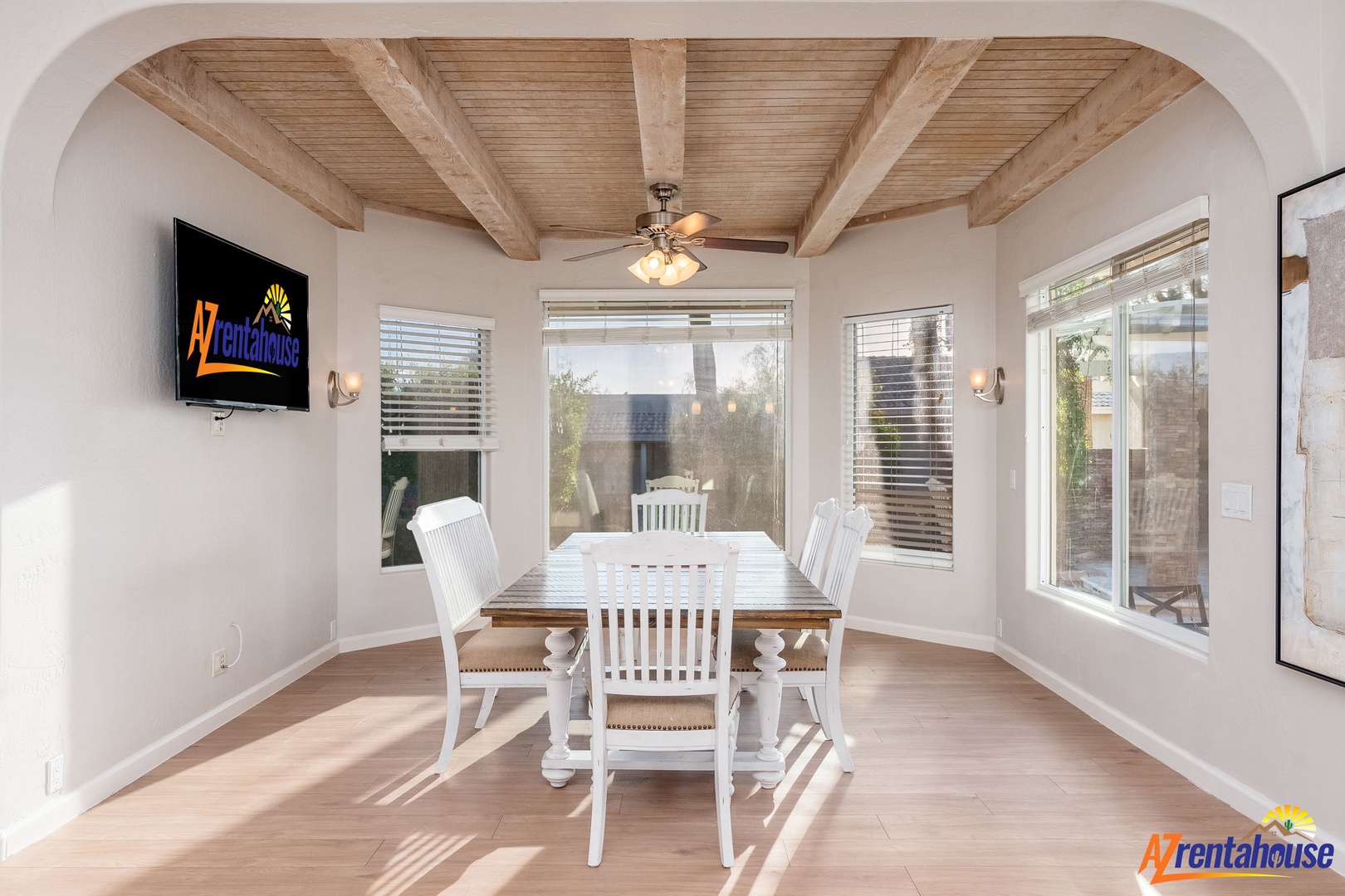 Your dining room features a stunning vaulted ceiling with natural wood beams, creating an airy, inviting space for memorable meals. Abundant windows frame tranquil outdoor views while sunlight warms the room.