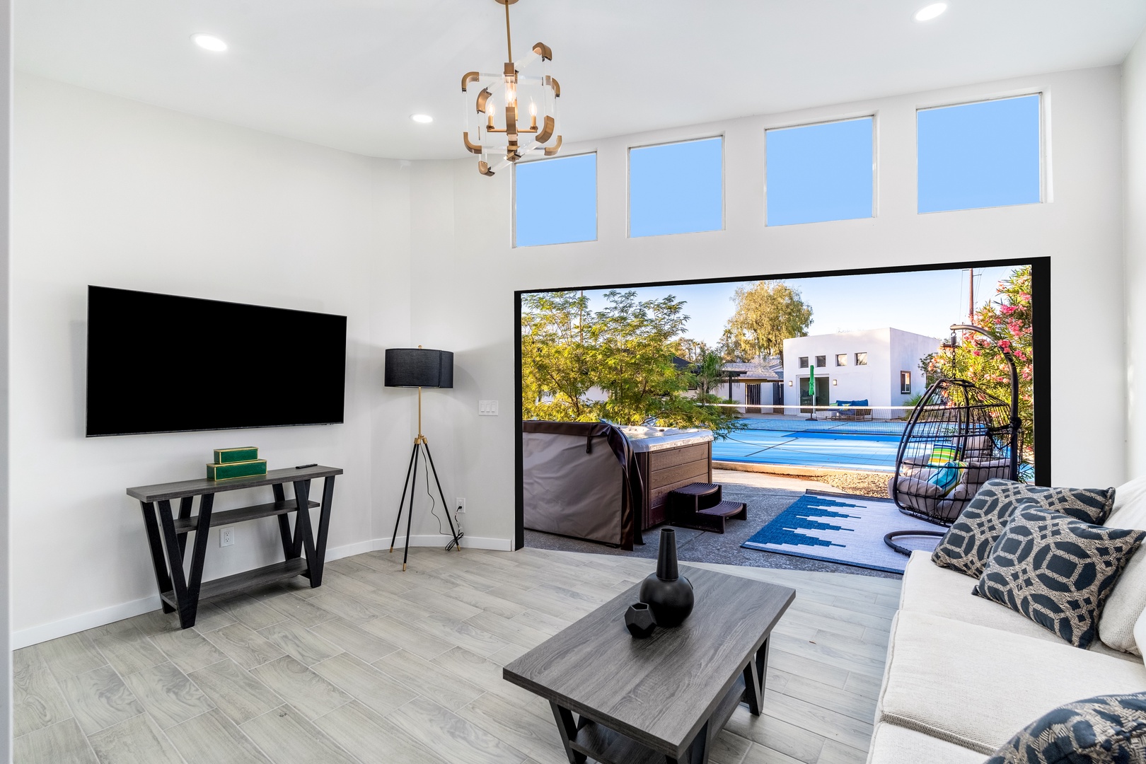 Your bright, modern living room flows seamlessly to the sparkling pool and sunny patio—perfect for relaxing indoors or stepping outside to soak up the warmth and views.
