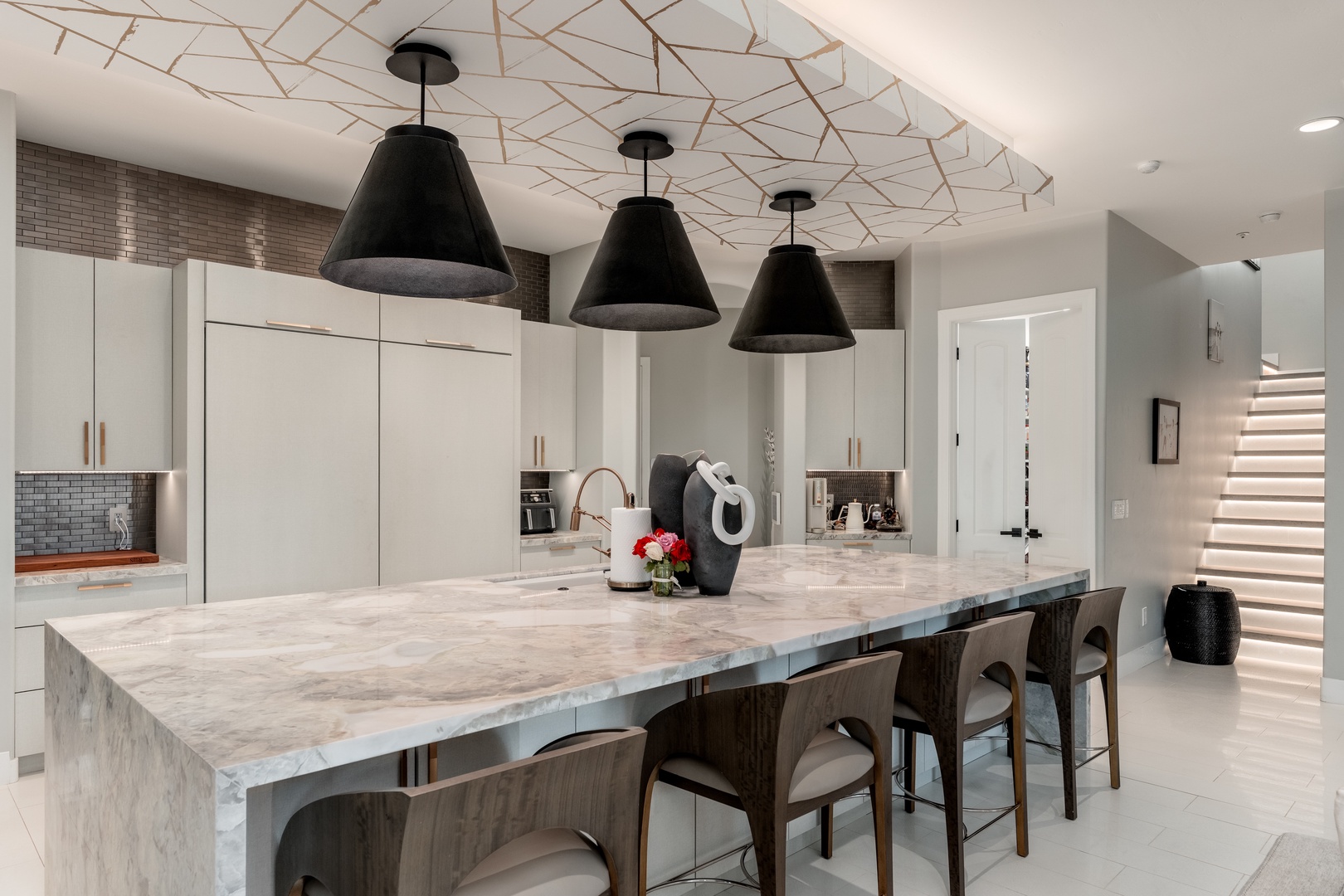 Gather at the marble-topped island in your stylish, modern kitchen, where sleek pendants illuminate your culinary adventures and every detail invites you to cook, share, and connect.