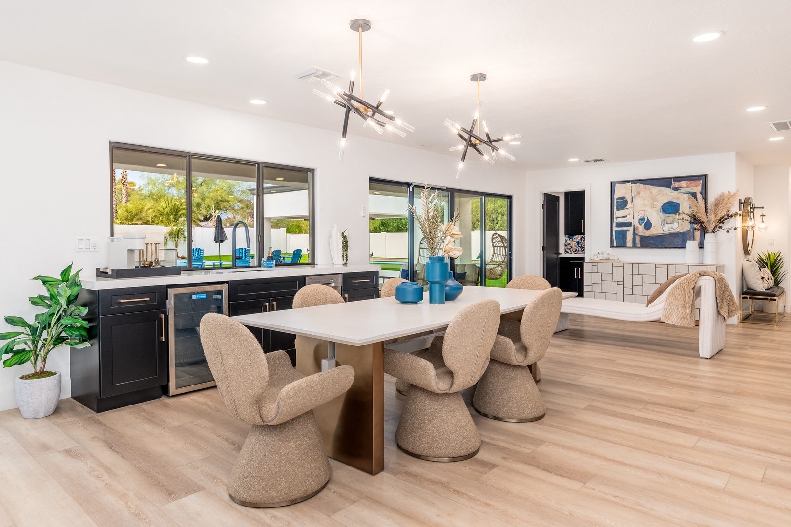 Gather around the sleek dining table where modern design meets comfort, with views of your private outdoor oasis just beyond the glass doors.