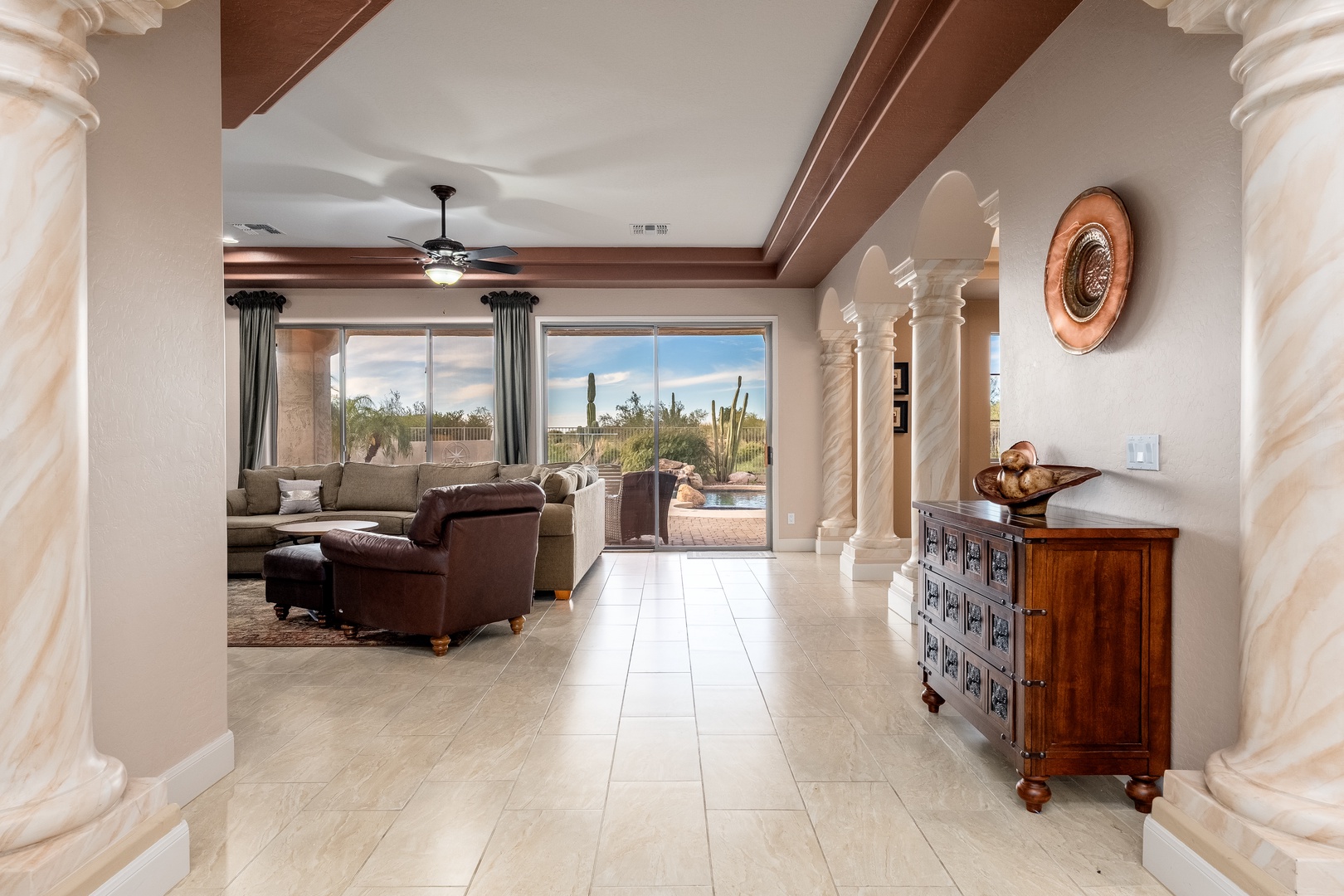 Step into your serene desert retreat where elegant columns frame sweeping views of saguaro-dotted landscapes. Sink into plush seating as natural light fills the open living space, inviting you to unwind and embrace the stunning Sonoran scenery beyond your