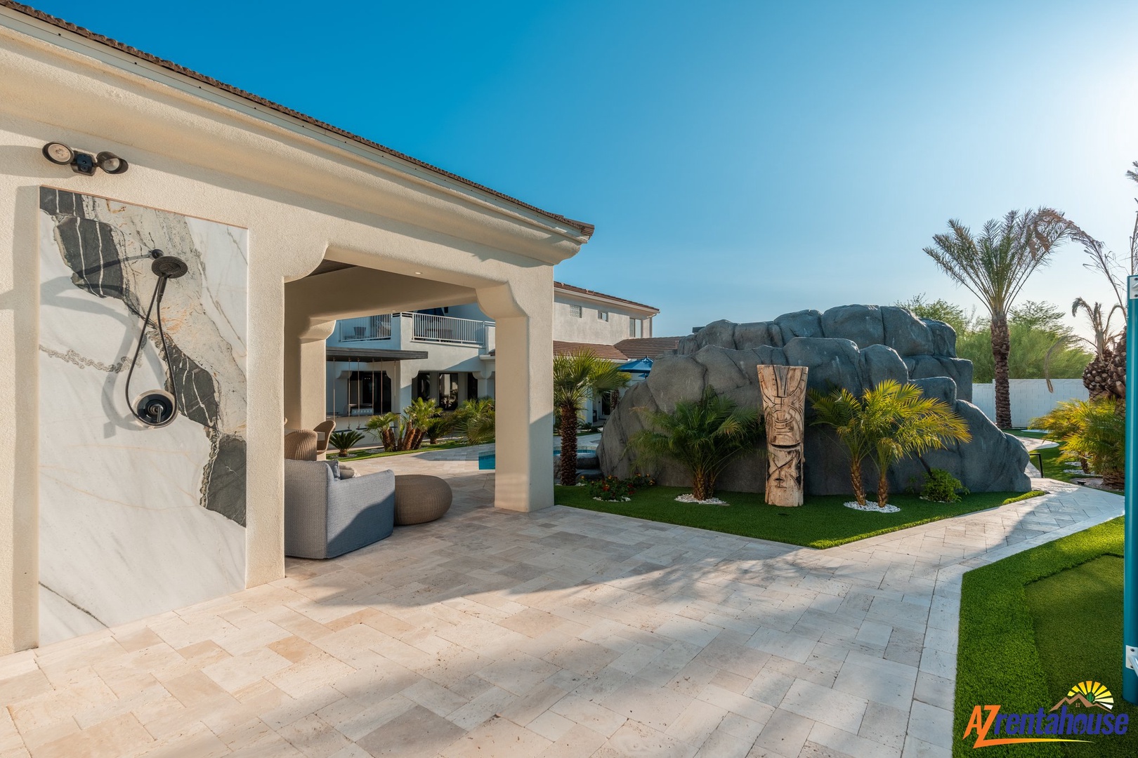 Modern luxury resort featuring poolside pavilion and tropical landscaping under clear desert skies.