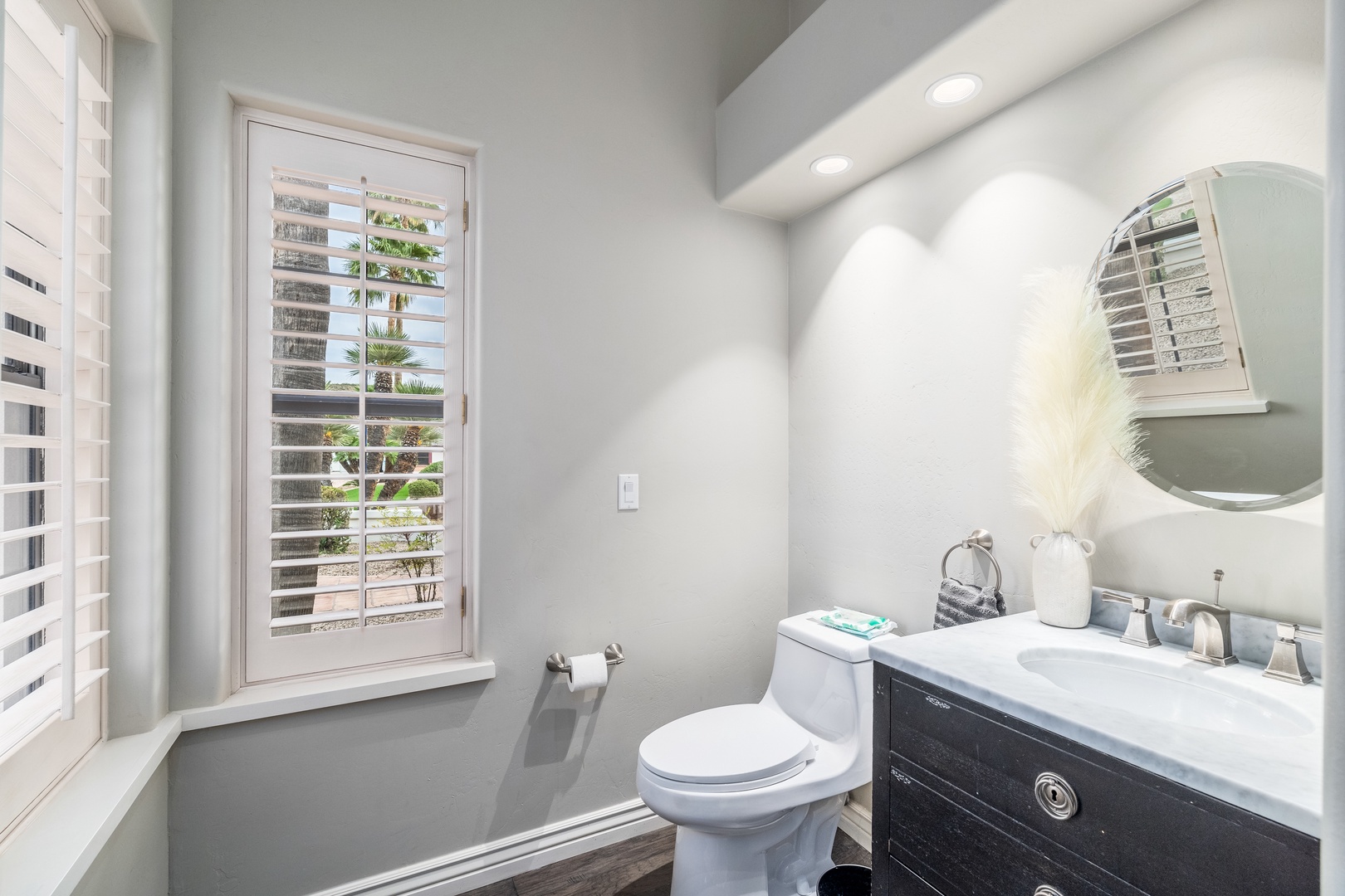 Step into your private bathroom with modern fixtures and natural light streaming through plantation shutters, creating a bright and peaceful retreat for your morning routine.