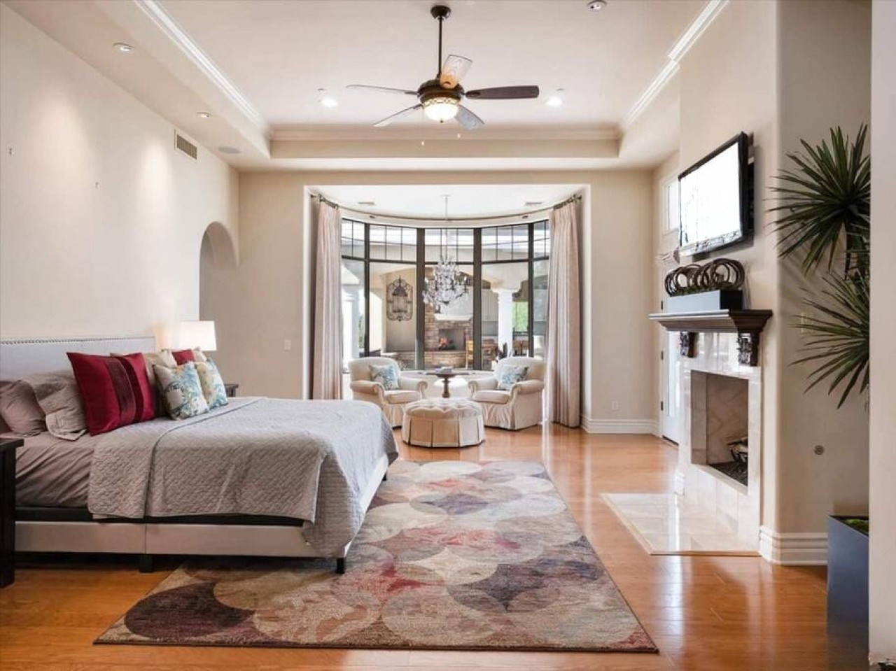 Sink into plush bedding and unwind in your elegant suite, where hardwood floors meet soft textures, a cozy fireplace awaits, and oversized windows invite natural light into your private retreat.