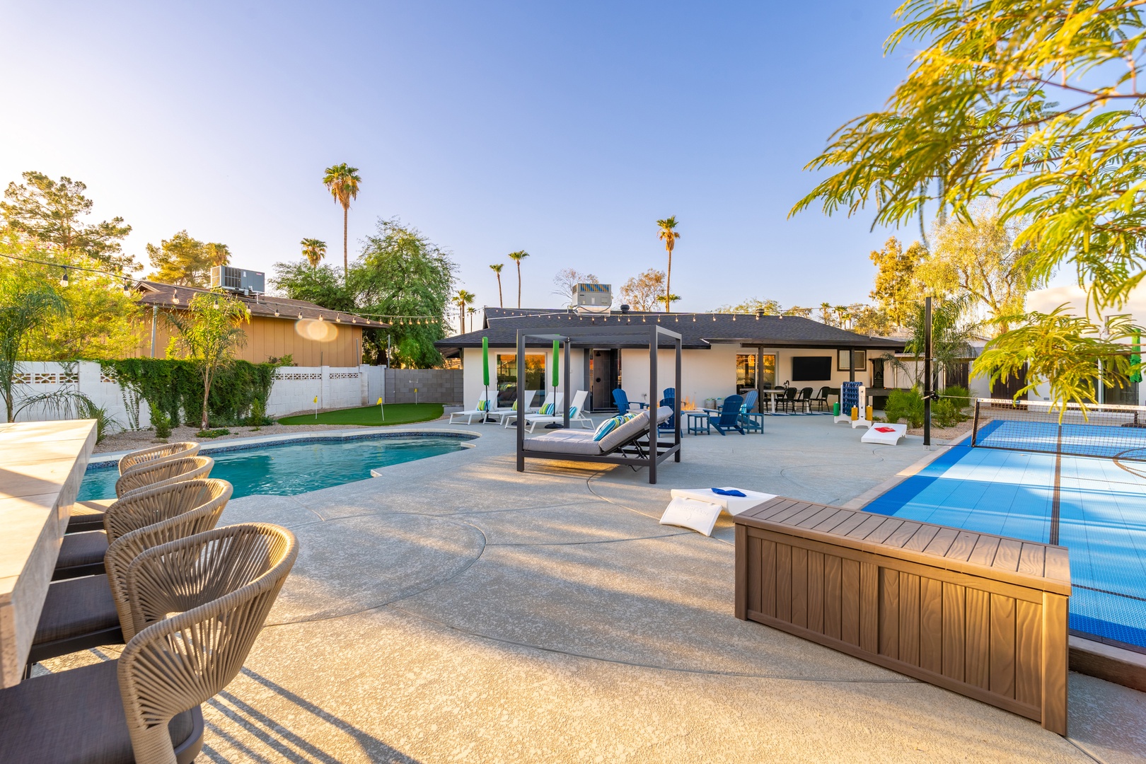 Expansive backyard oasis featuring dual pools, lounge seating, and covered patio—perfect for sunny days and starlit evenings with friends and family.