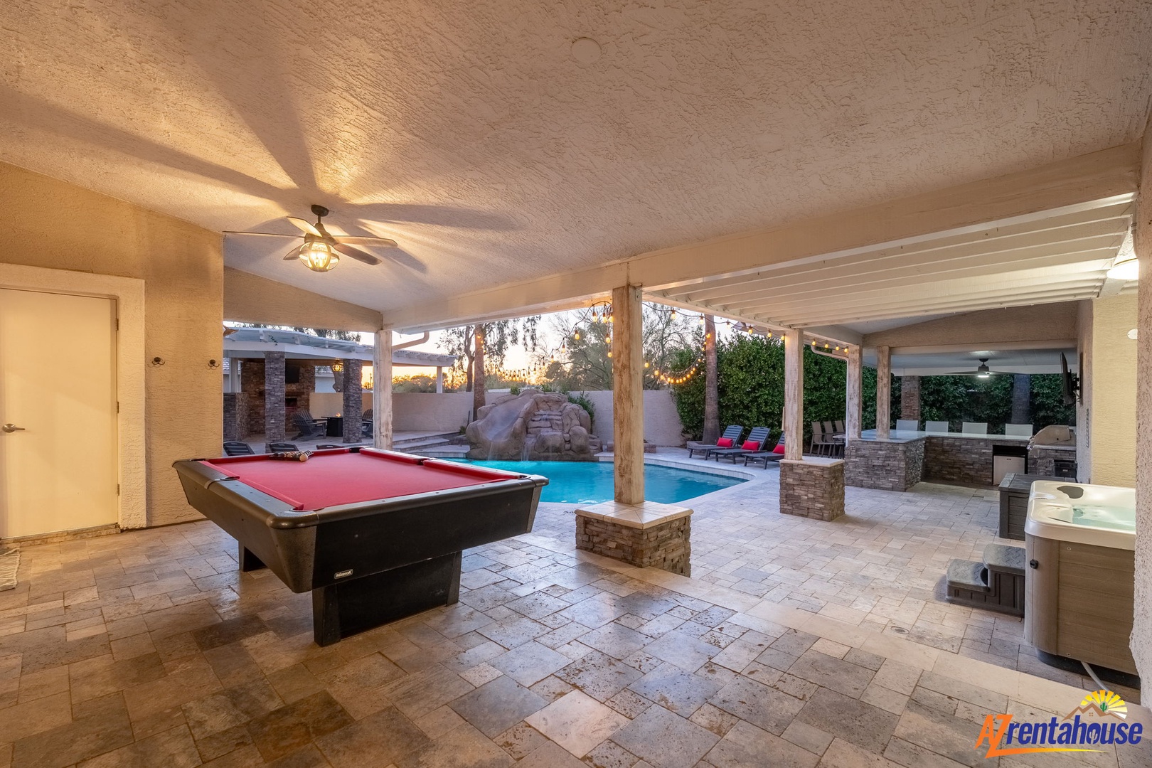 A covered entertainment area featuring a pool table opens directly to your private pool and hot tub, creating the perfect space for fun and relaxation any time of day.
