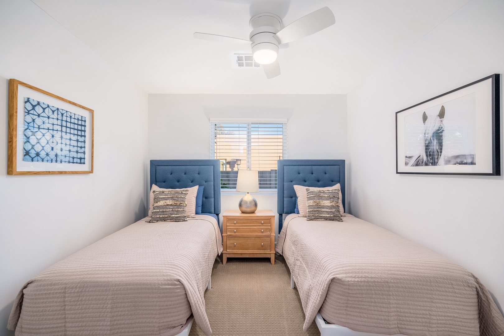 Your serene twin bedroom features plush upholstered headboards, calming artwork, and soft linens for a restful night's sleep after your adventures.