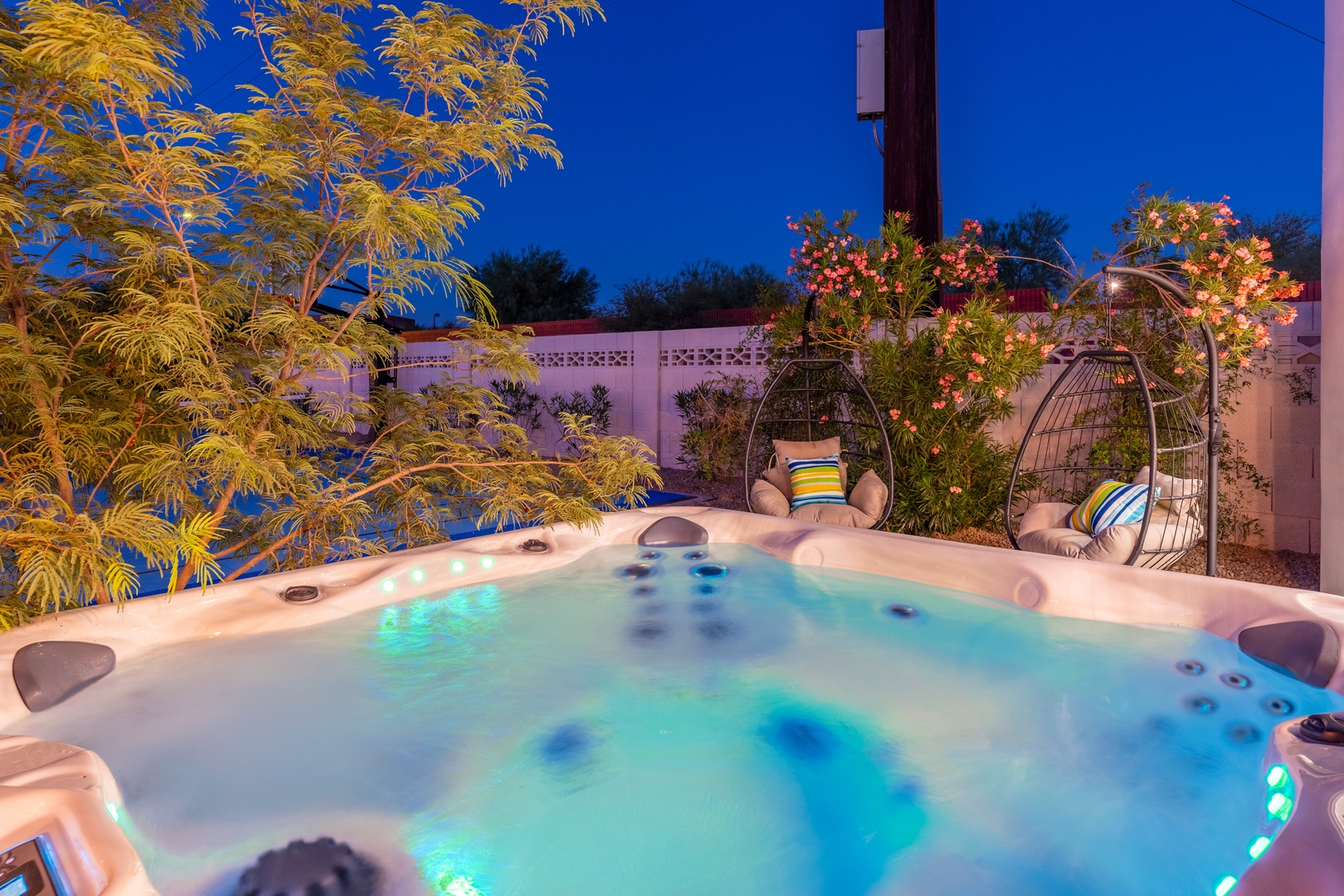 Soak under the stars in your private hot tub, surrounded by lush gardens and cozy hanging chairs—perfect for unwinding after a day of desert adventure.