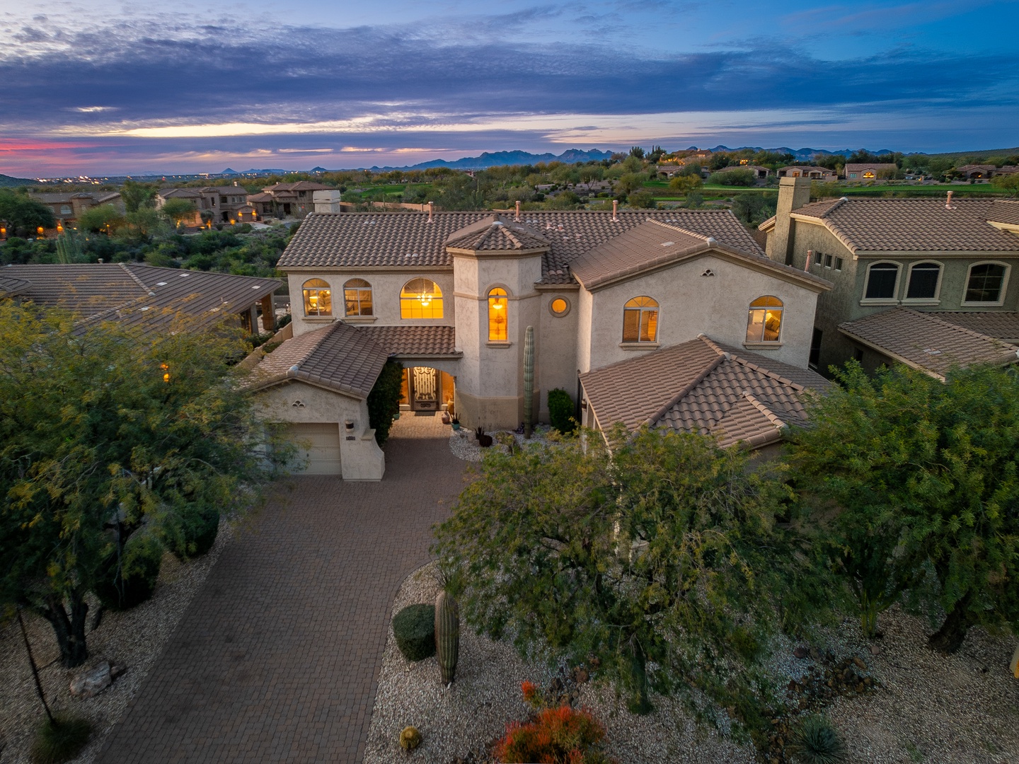 Elegant Mediterranean-style home nestled in desert foothills with stunning mountain vistas, surrounded by native desert landscaping and peaceful desert scenery.
