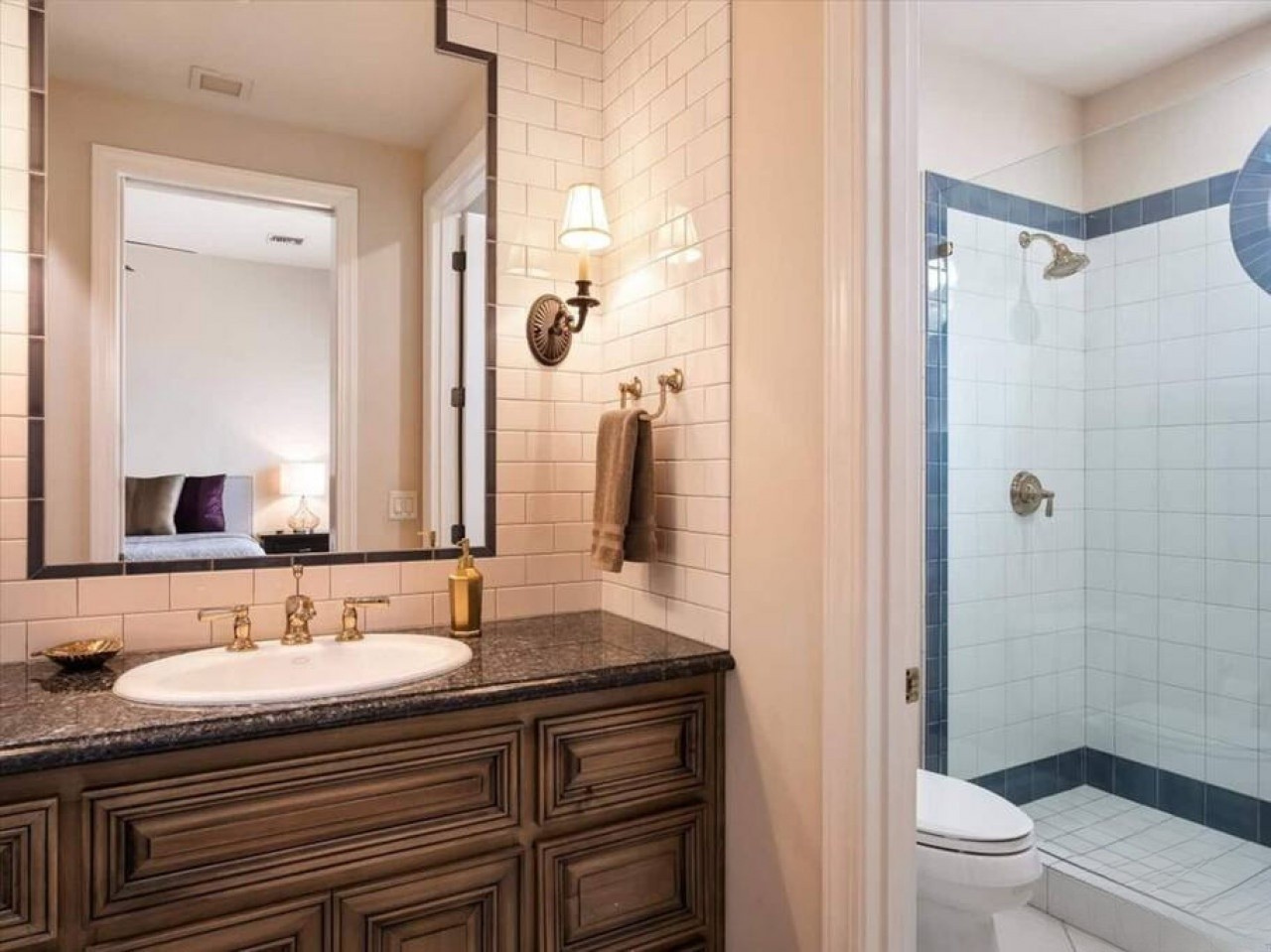 You'll love starting your day in this polished bathroom with classic subway tiles, a spacious vanity, and a refreshing walk-in shower with crisp blue accents.