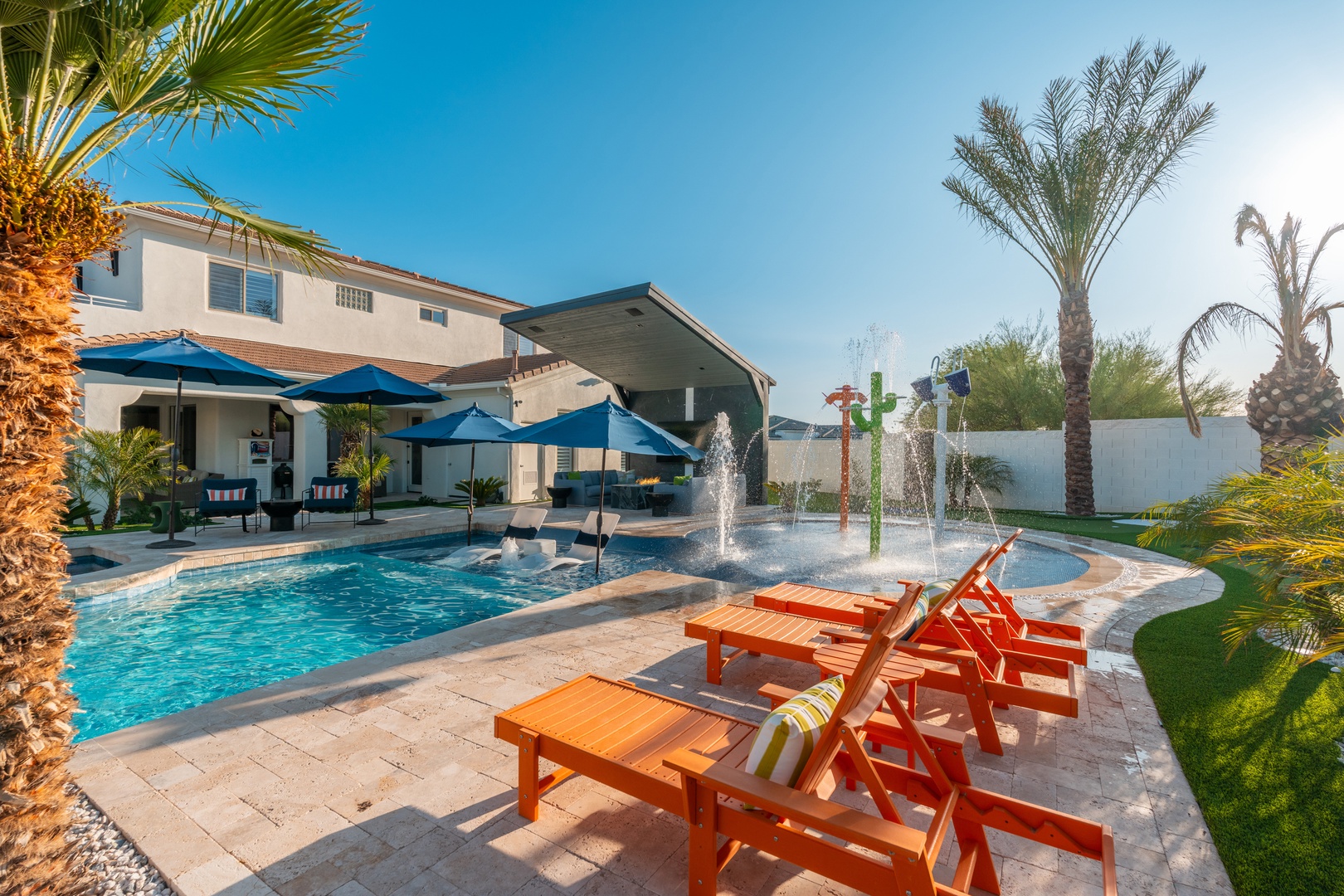 Soak up the sunshine on colorful loungers by your private pool, complete with playful splash features and shaded seating—your perfect desert oasis awaits.