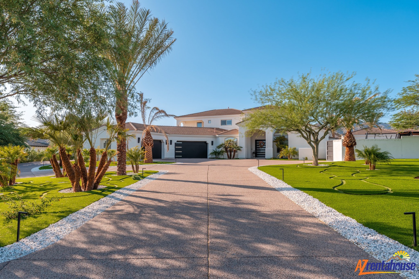Modern desert villa set among palm trees and manicured lawns creates an impressive arrival experience in this upscale neighborhood.