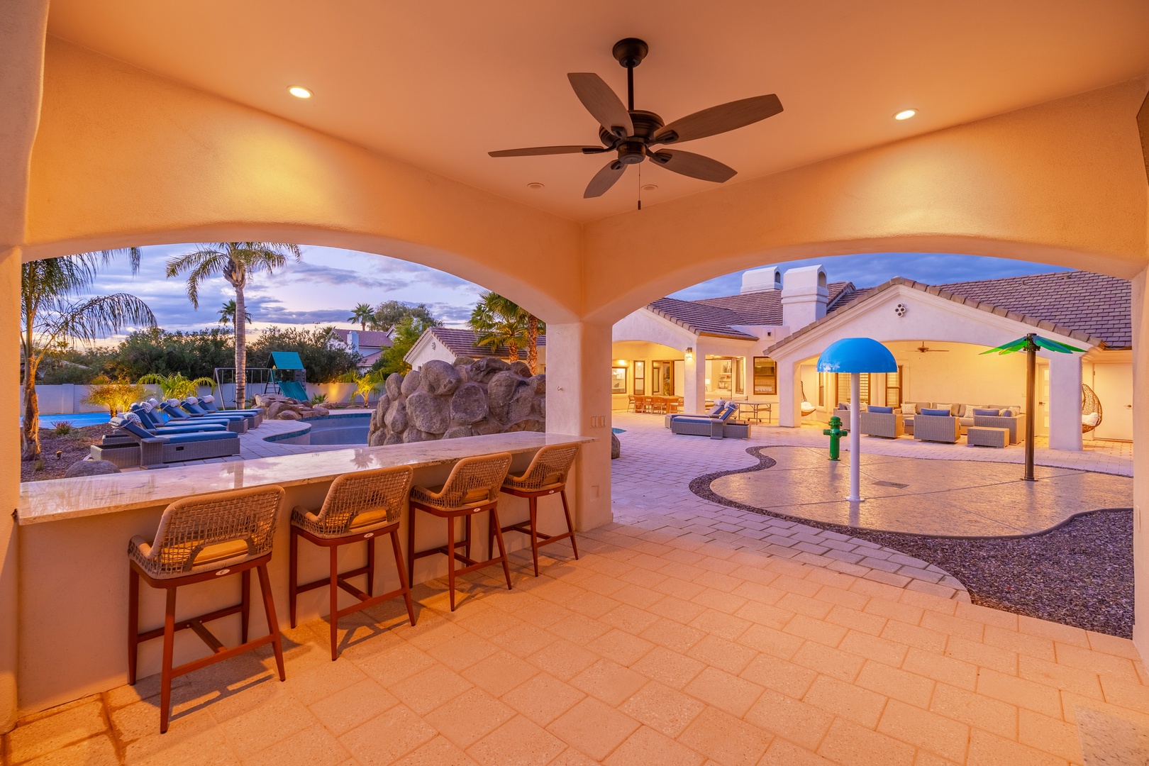 Gather at your private poolside bar as twilight falls—mix drinks, share stories, and soak in the warm desert evening under elegant archways with resort-style outdoor living at your fingertips.