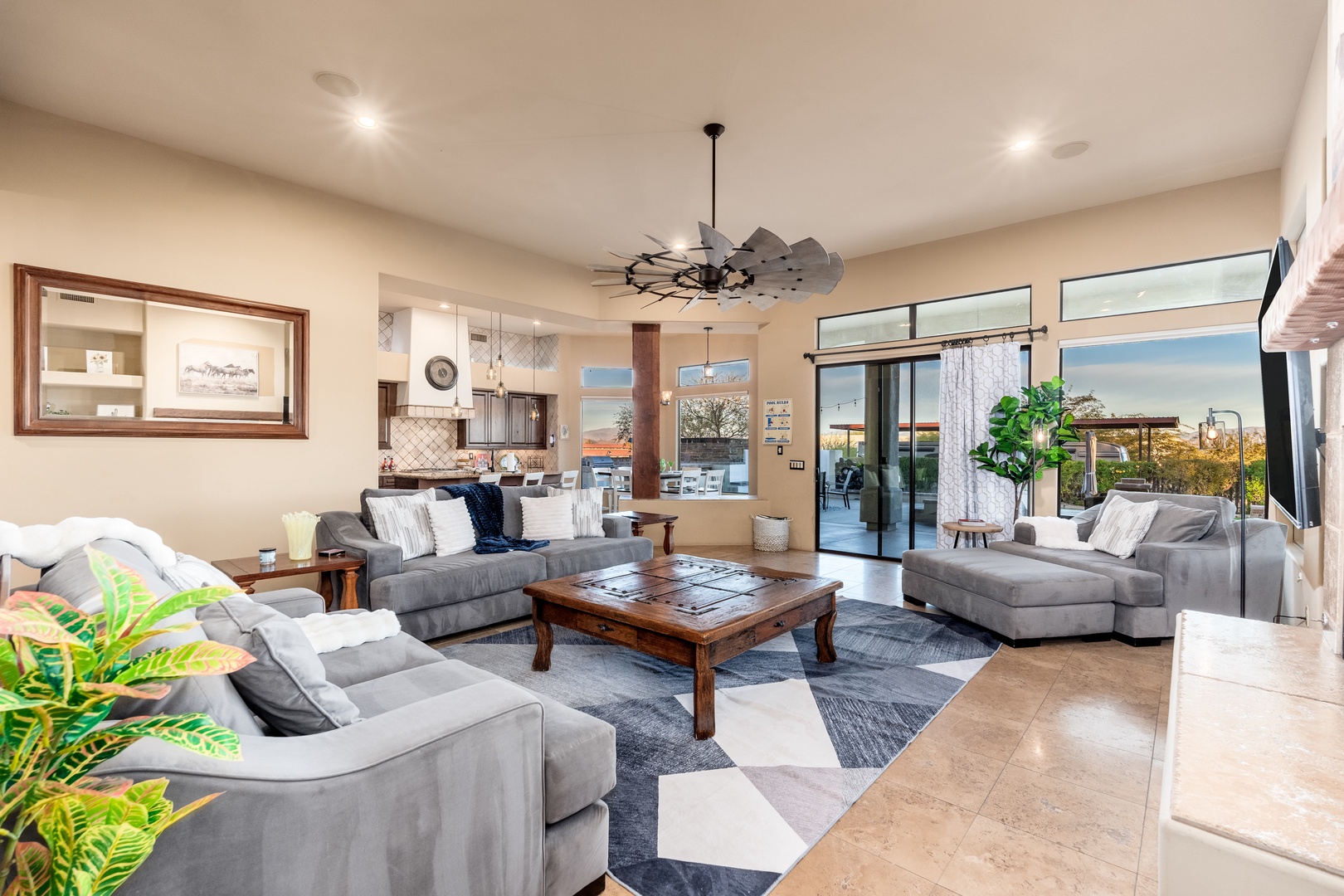 Sink into plush sofas where natural light pours in through expansive glass doors. Your open-concept retreat connects seamlessly to outdoor living, with a modern kitchen just steps away.