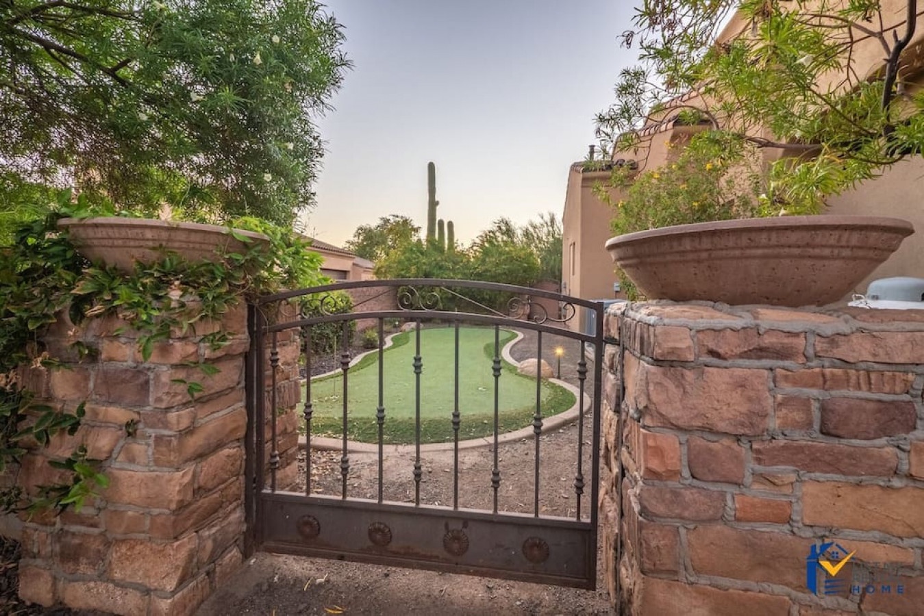 Property entrance features handcrafted stone walls and decorative ironwork, welcoming guests to desert tranquility.