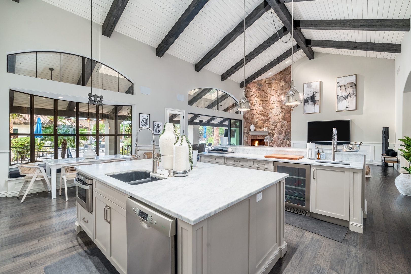 Soaring ceilings with exposed beams frame your gourmet kitchen, where gleaming marble counters and top-tier appliances invite you to create culinary masterpieces in style and comfort.