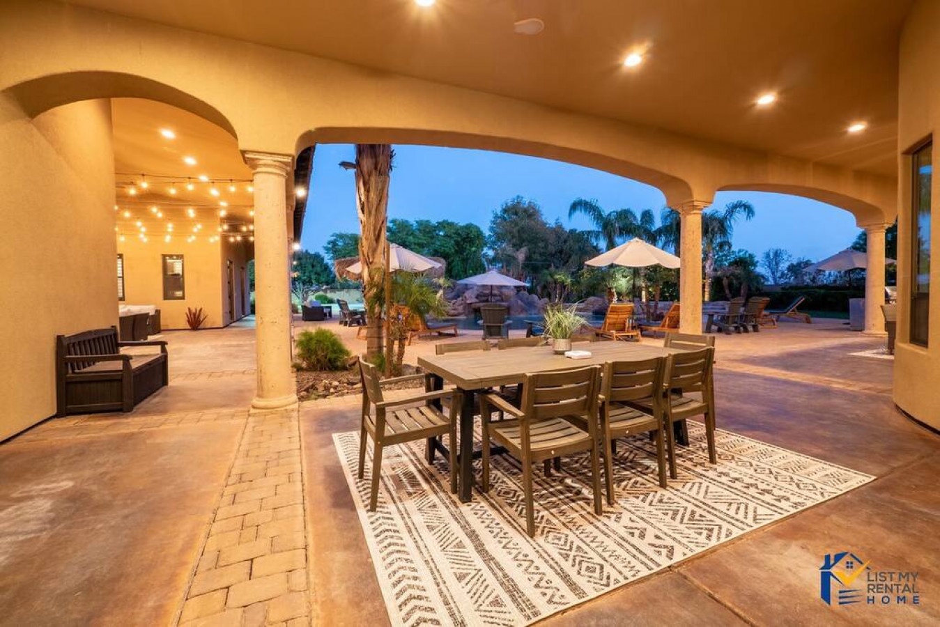 Gather around your private outdoor dining table under elegant arches, where warm lighting creates the perfect ambiance for memorable meals.