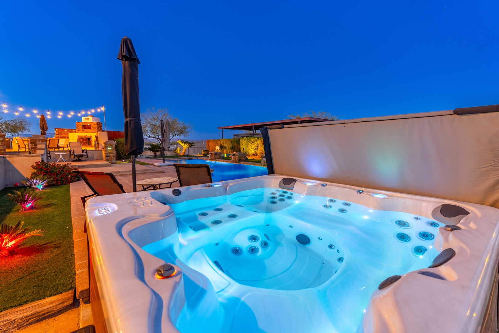 Soak in bubbling warmth as the sun sets, with glowing views of your private pool and beautifully lit outdoor living spaces stretching before you.