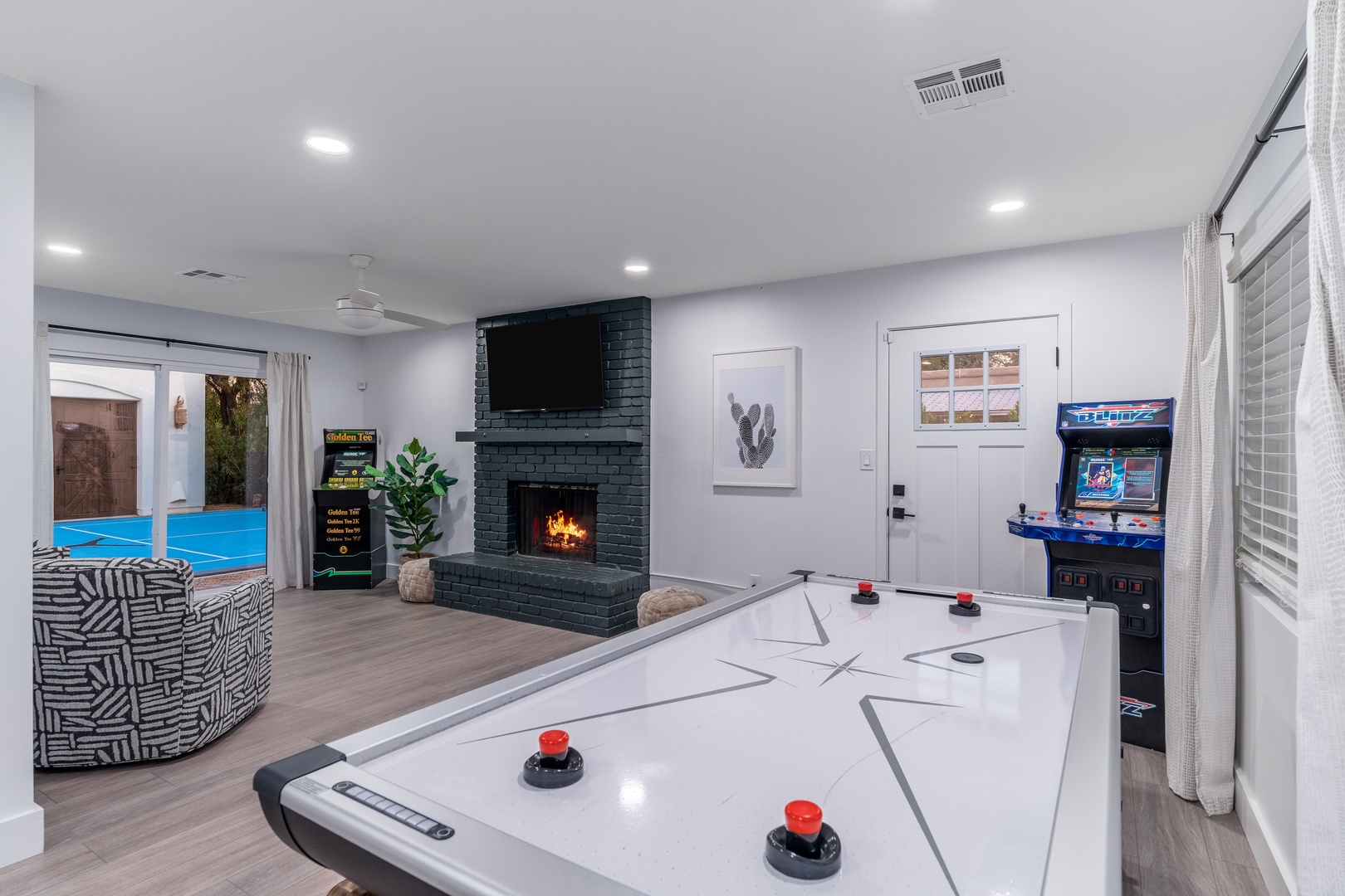 Your entertainment hub awaits with arcade games, air hockey, and a cozy fireplace, opening to your private pool for endless fun-filled days.