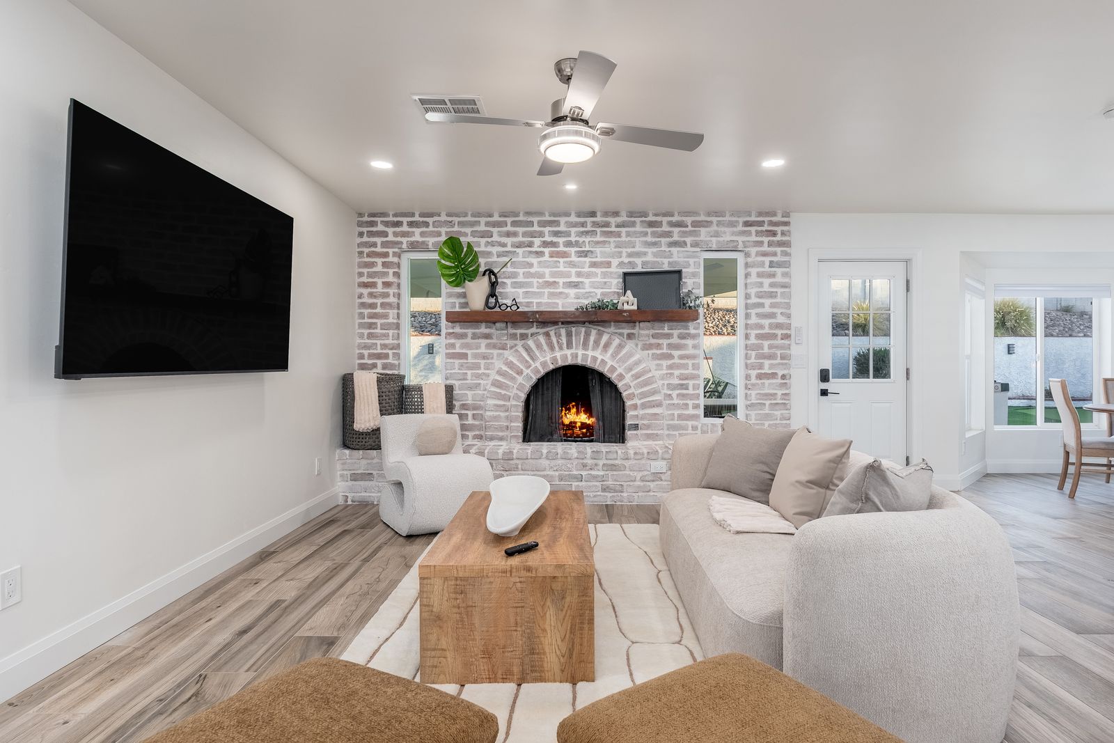 Sink into plush seating in this inviting living room, where a warm brick fireplace and modern entertainment setup promise cozy evenings after your adventures.