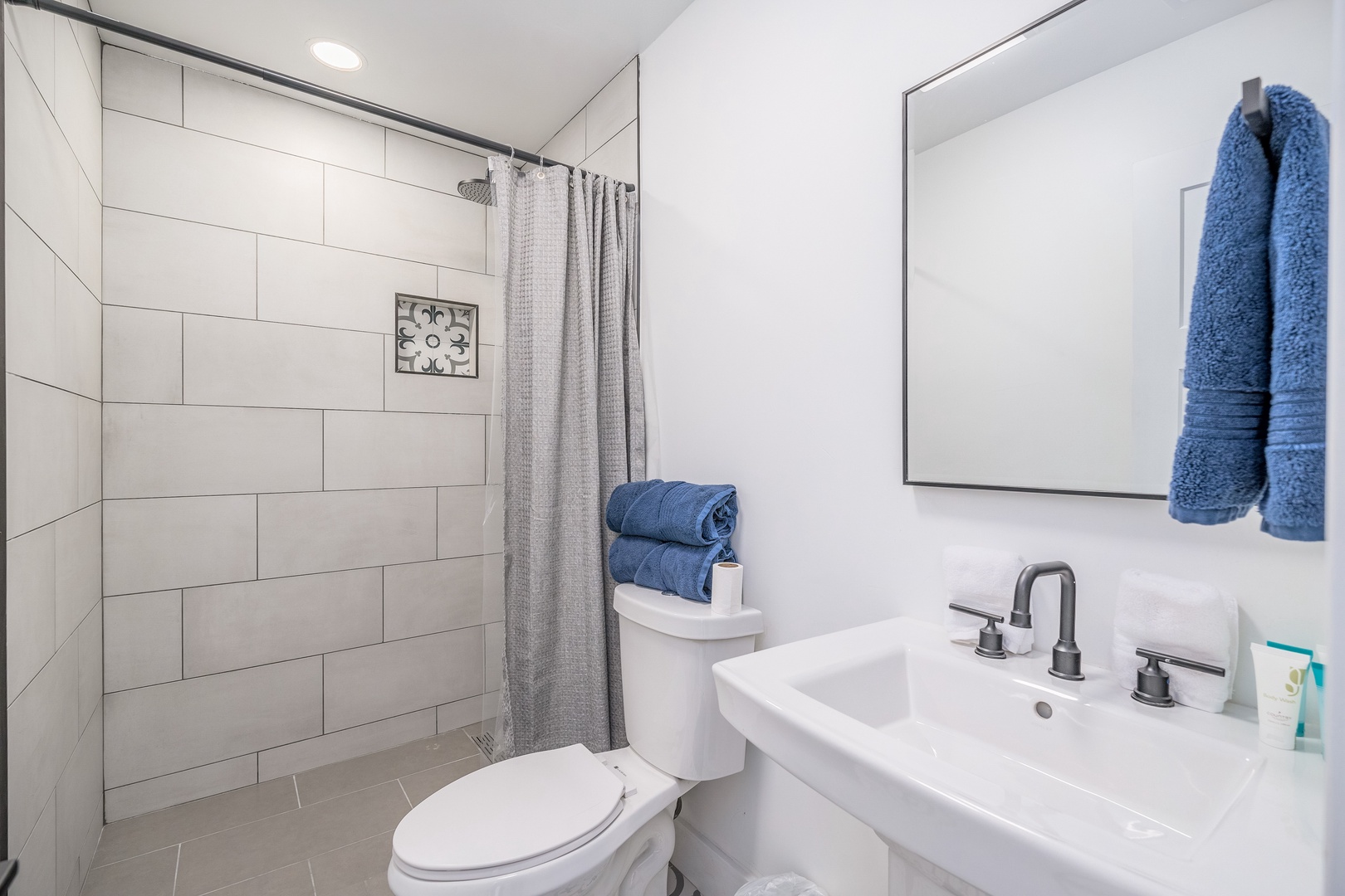 Modern bathroom offering a walk-in shower, plush towels, and fresh amenities to keep you refreshed and comfortable throughout your stay.