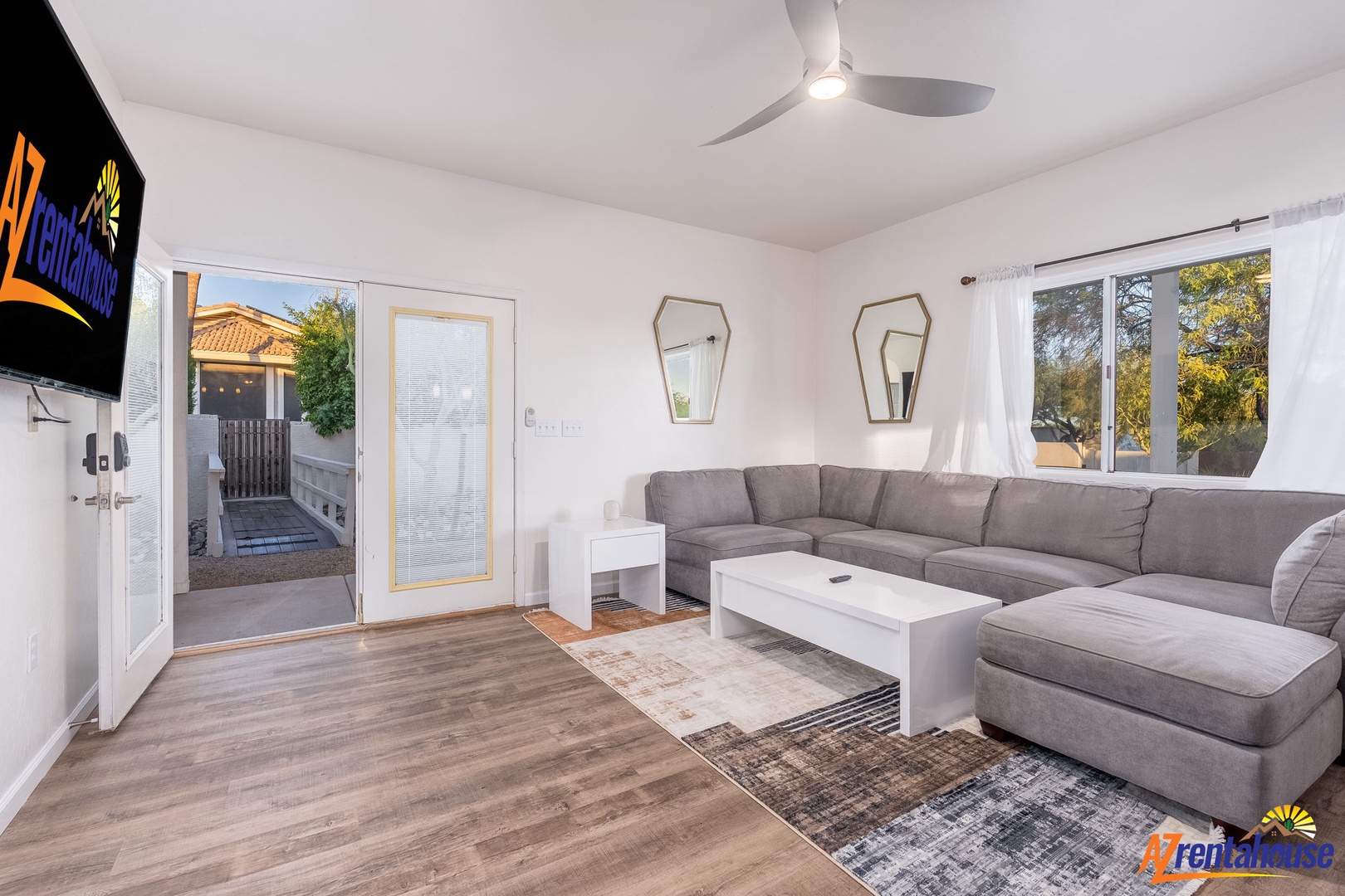 Settle into your bright, modern living room with plush sectional seating, a ceiling fan to keep you cool, and doors opening to your private outdoor space.